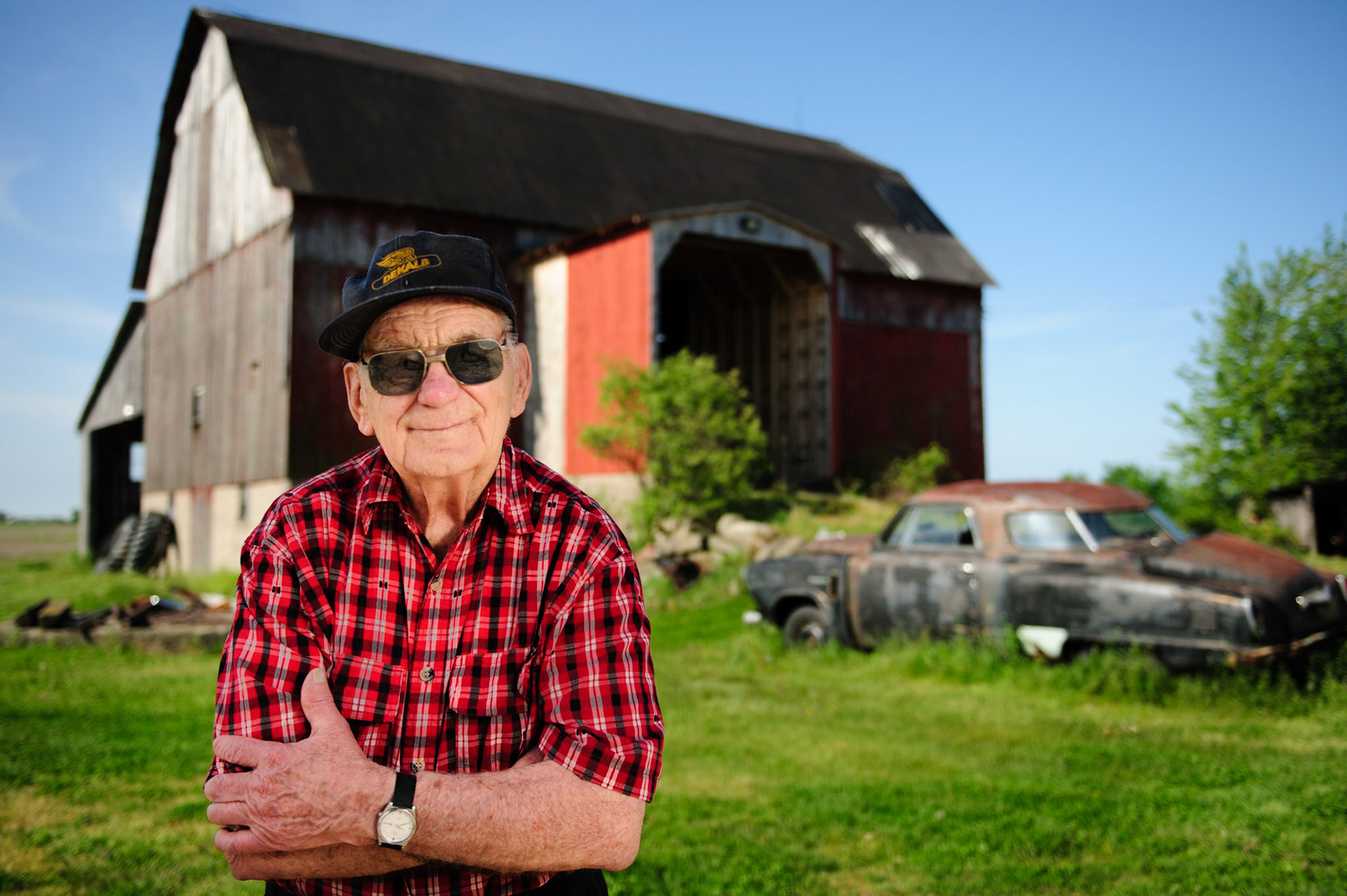 This is my Great Uncle Jack standing infront of his barn that was build in 1906. It withstood the F4 tornato that hit Leamington, Ontario in 2010. Just to the right of the frame is a newer steal barn that didn't fair so well. The door was found 400 meters across the road.  My uncle was 89 in this photo, and he's lived on this property since the 30's.  Nikon D3, SB-900/910. 2012