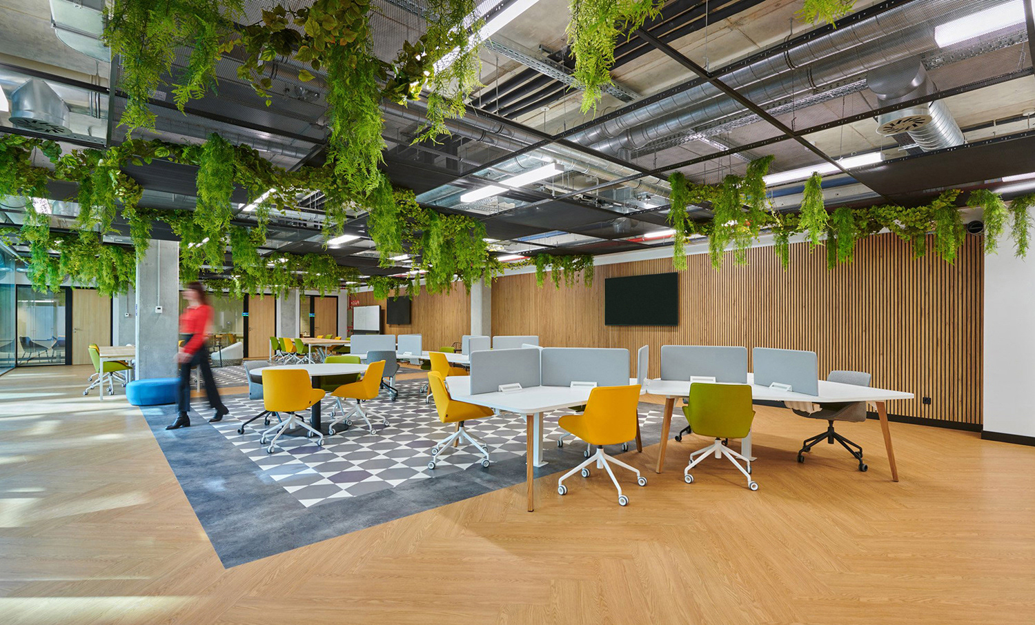 TravelPerk office with open collaborative workspaces, desk clusters and breakout seating.