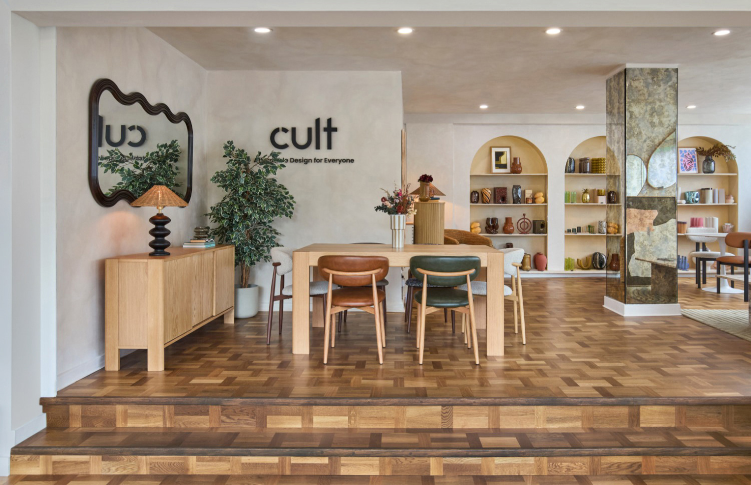 Cult Furniture showroom interior with a wooden dining table, modern chairs and wall shelving.