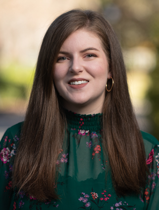 Olivia smiling wearing a green blouse outdoors