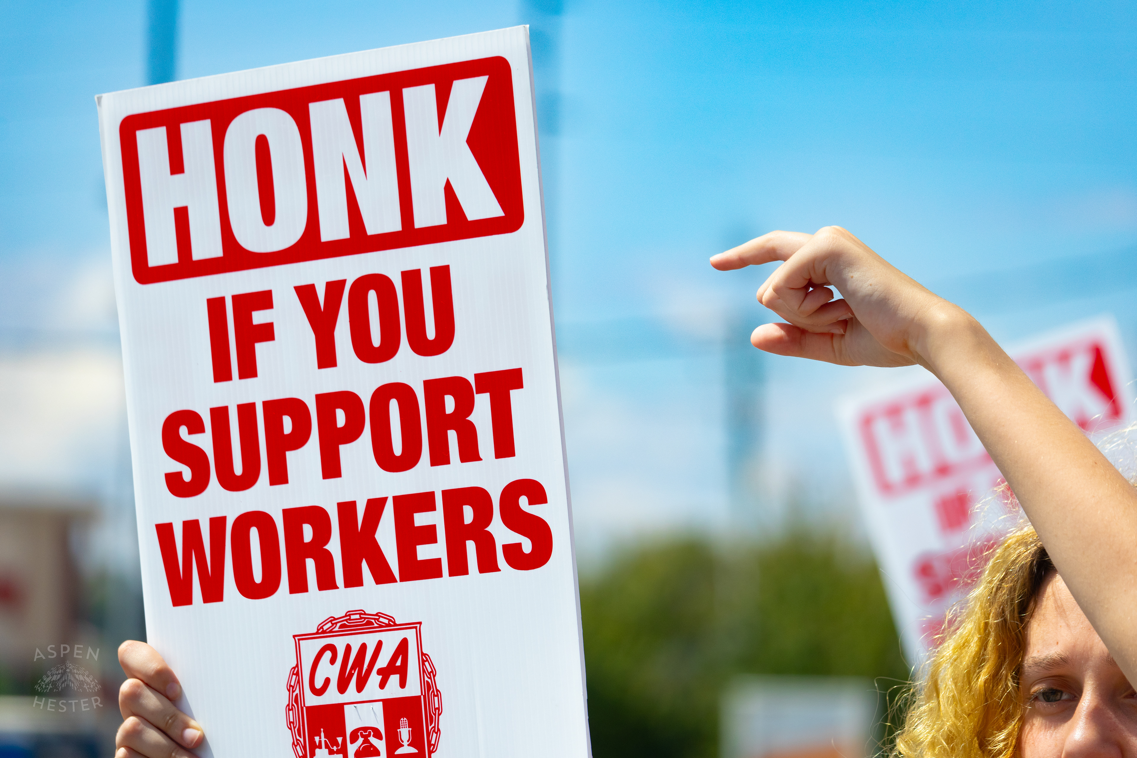 Picketer Encourages Cars to Honk in Support of The Communication Workers of America Union Strike Against AT&T for Fair Pay and Benefits. August 18th, 2024/Aspen Hester