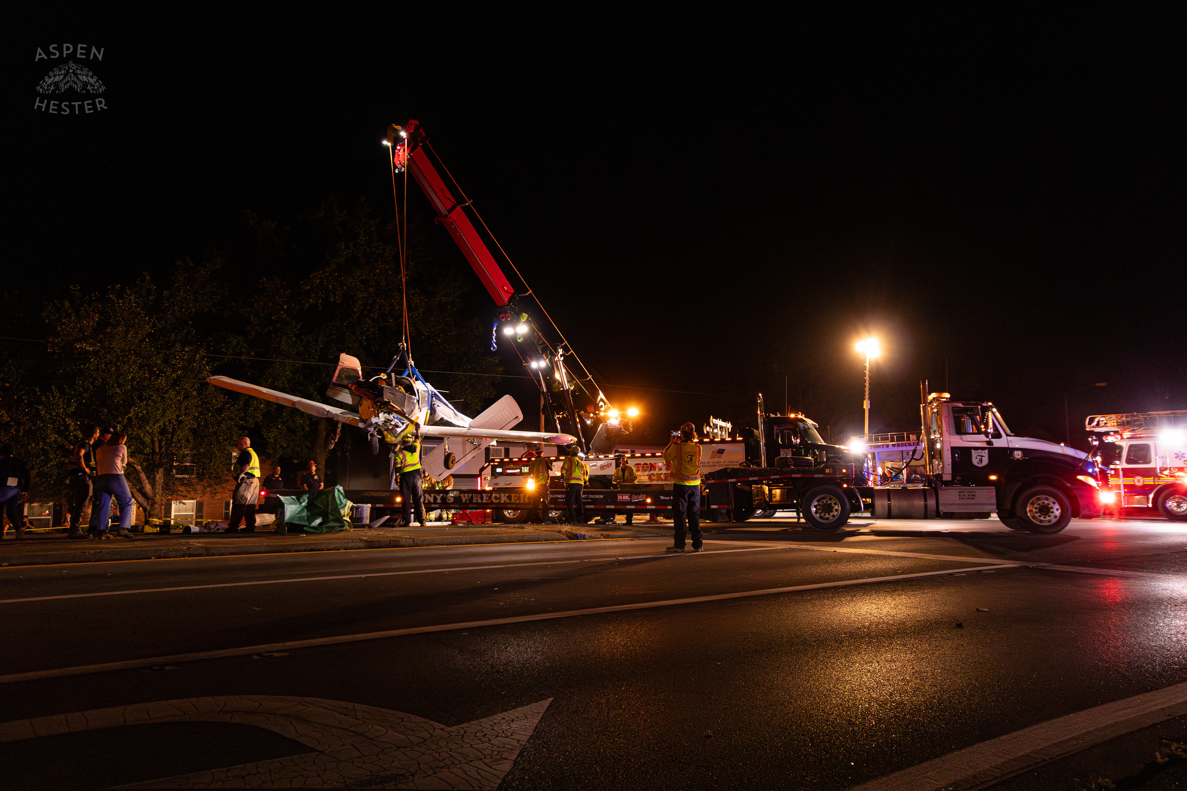 The Piper Cherokee Plane Being Lifted from the Road and Placed on A Flatbed Truck after it Crash Landed, Taking Out Utility Poles, and Hitting A Car on Breckenridge Lane and Kresge Way. October 11th, 2024/Aspen Hester 