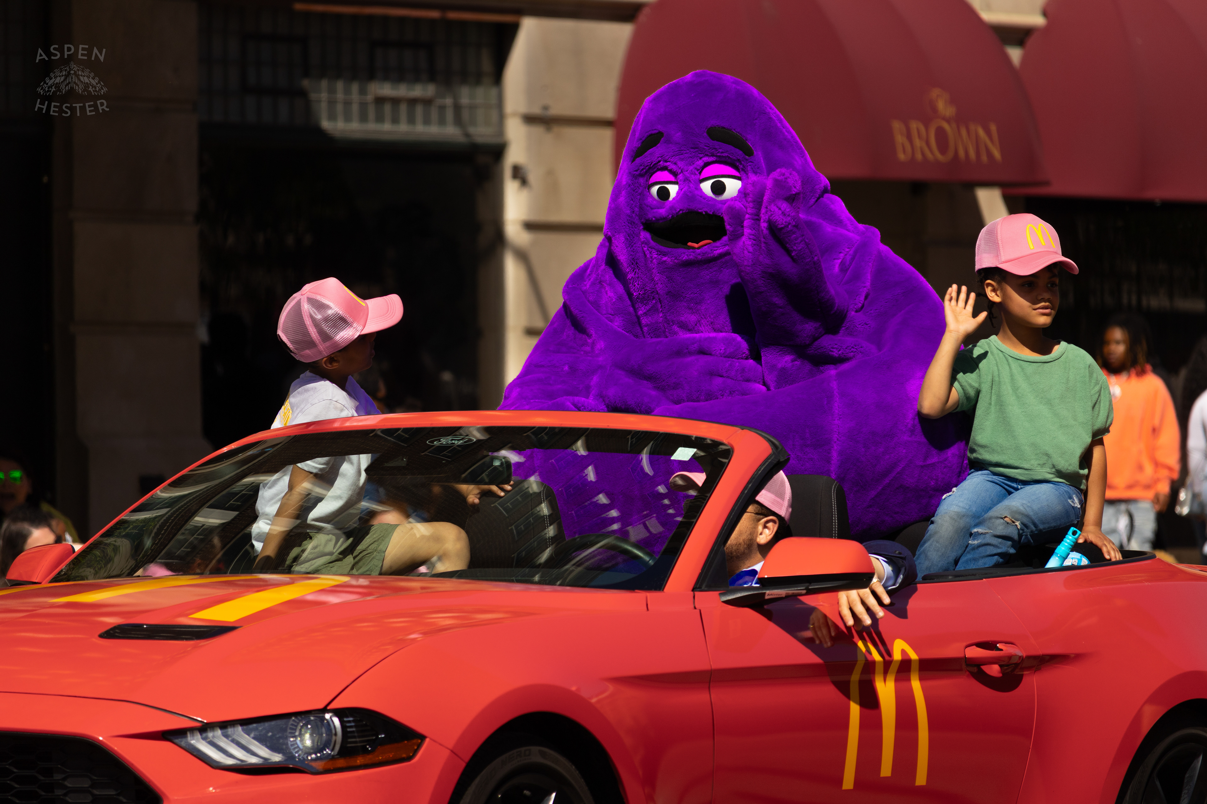 Grimace Rides Down West Broadway Waving at Children Screaming his name during The 70th Annual Pegasus Parade. April 27th, 2025/Aspen Hester