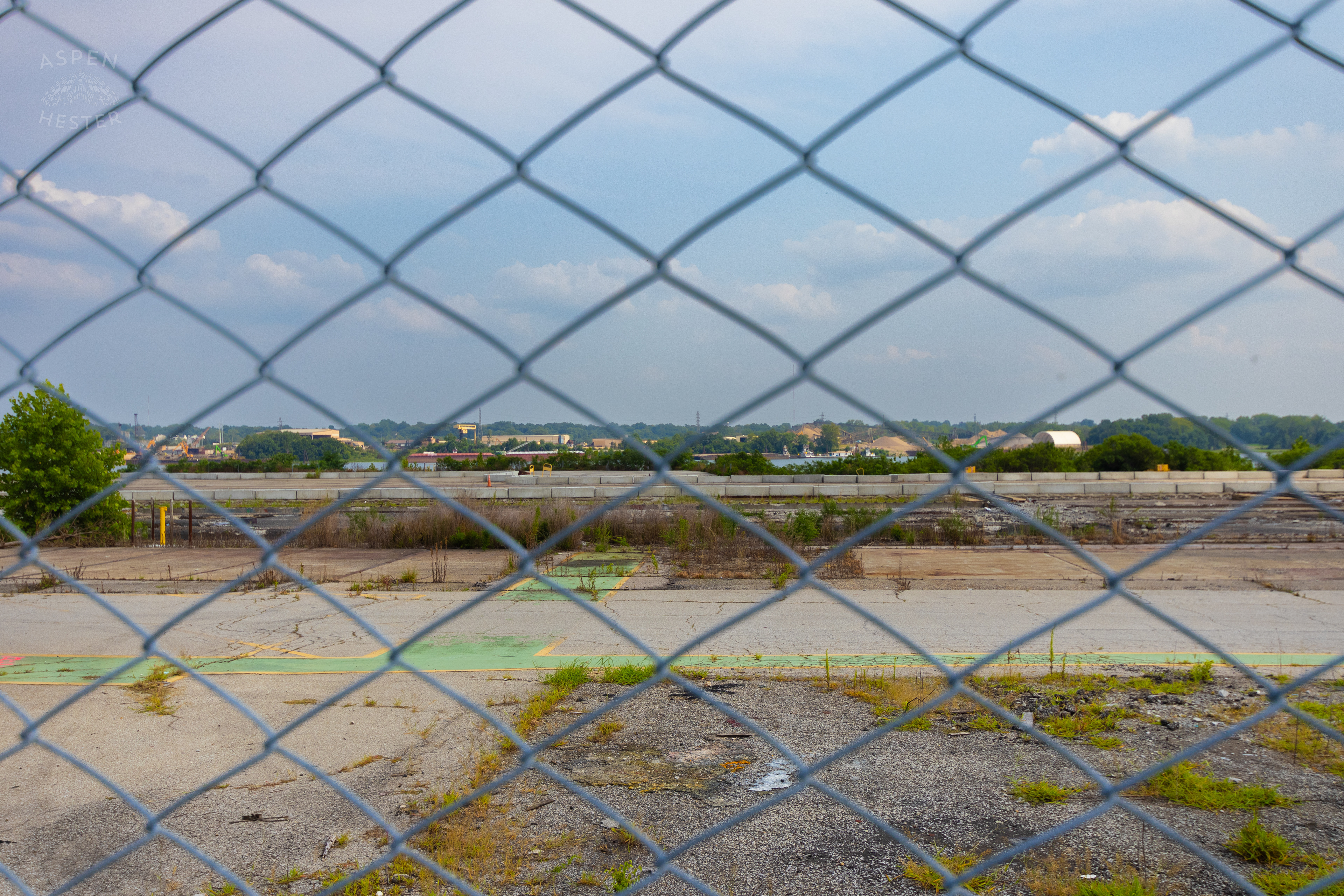 Looking Through the Chain Link Fence at the Abandoned Jeffboat Shipyard. July 26th, 2024/Aspen Hester