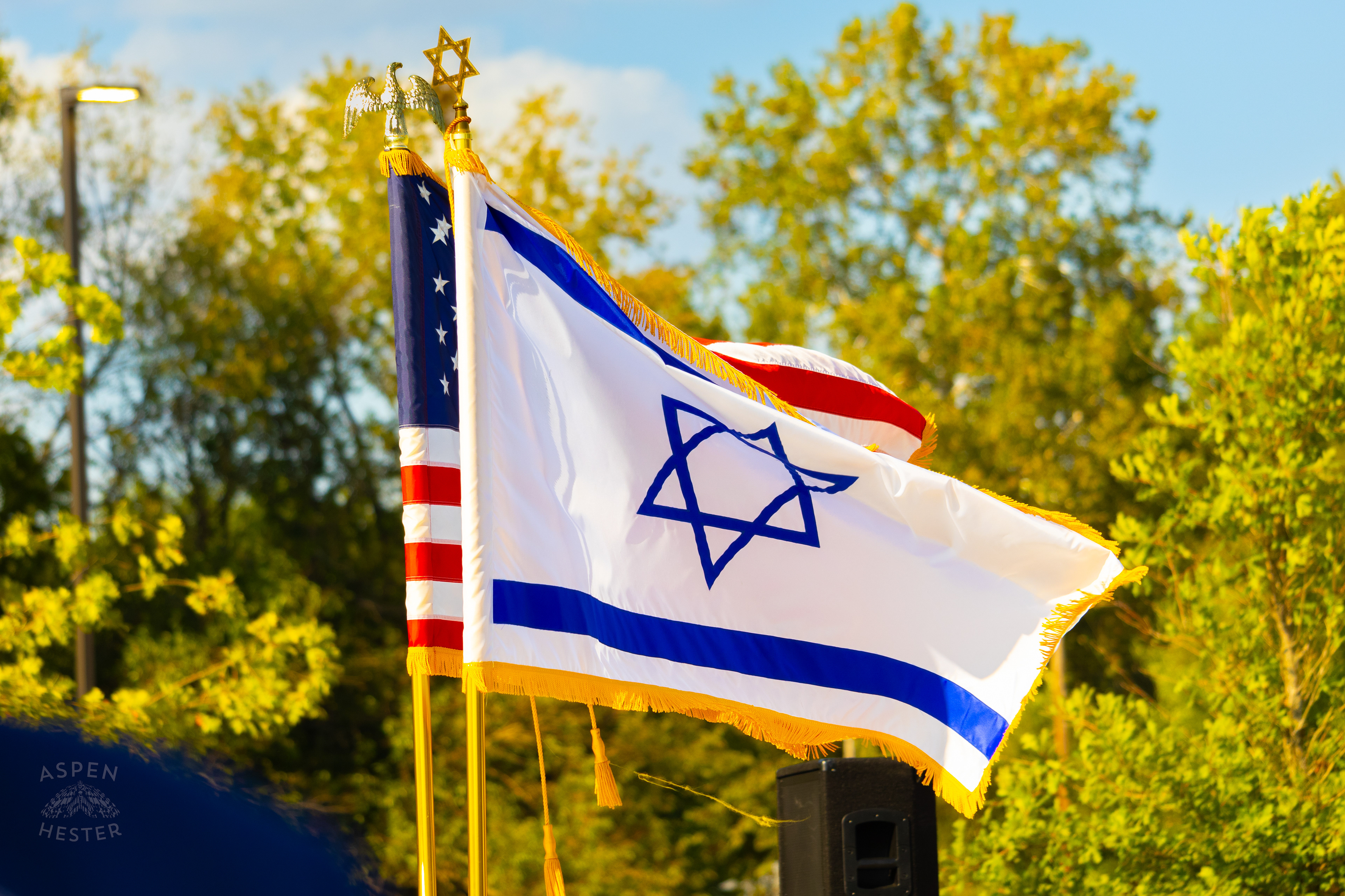 Jewish and American Flags Fly Over The Crowd Gathered at The Trager Jewish Community Center to Remember The Victims and Pray for Peace One Year After The October 7th 2023 Hamas Attack. October 6th, 2024/Aspen Hester