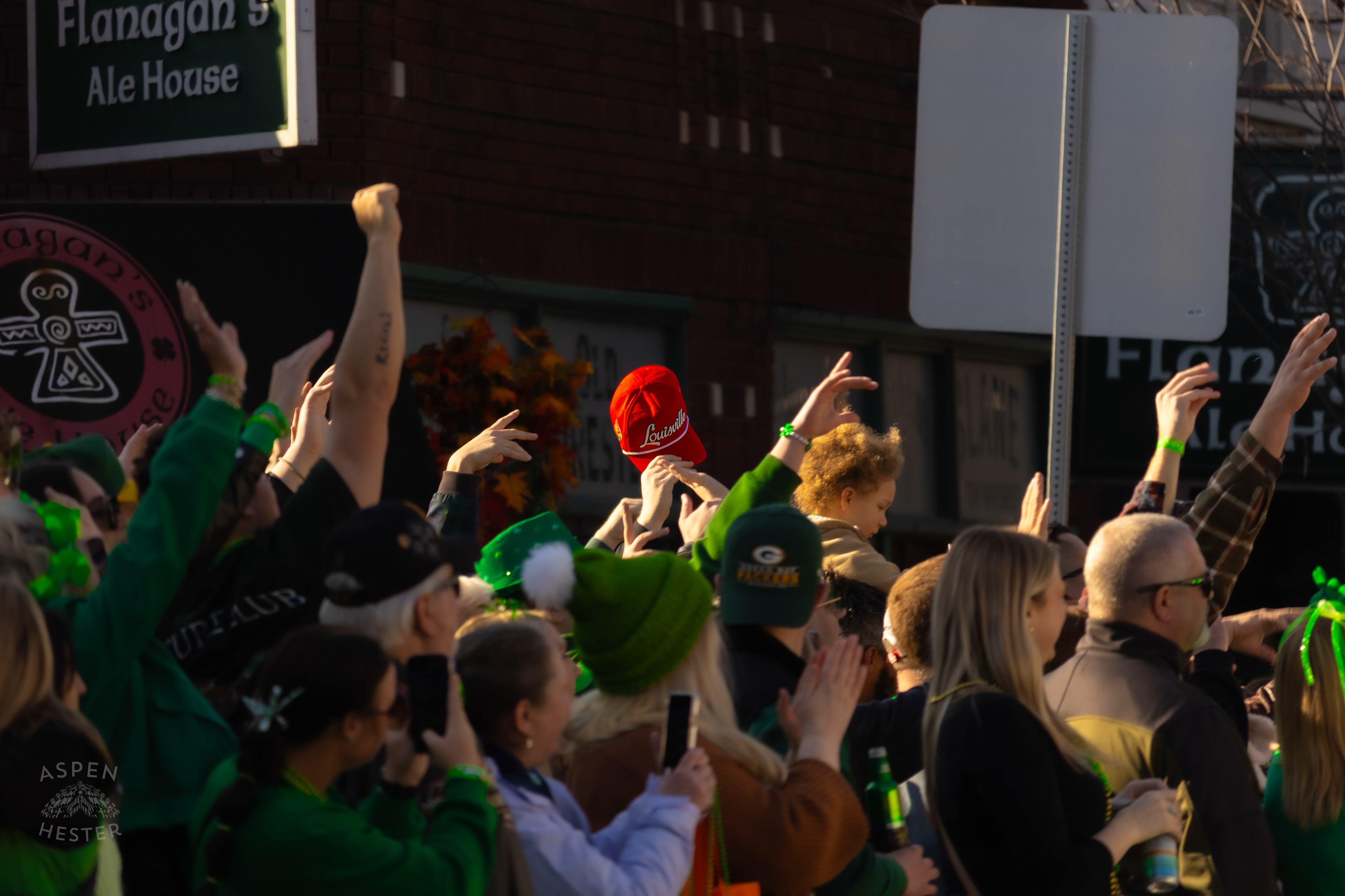 A Contrasting Red Louisville Cards Hat in The Sea of Green Apparel as The 52nd Annual Saint Patrick’s Day Parade Rolls Through The Highlands. March 8th, 2025/Aspen Hester