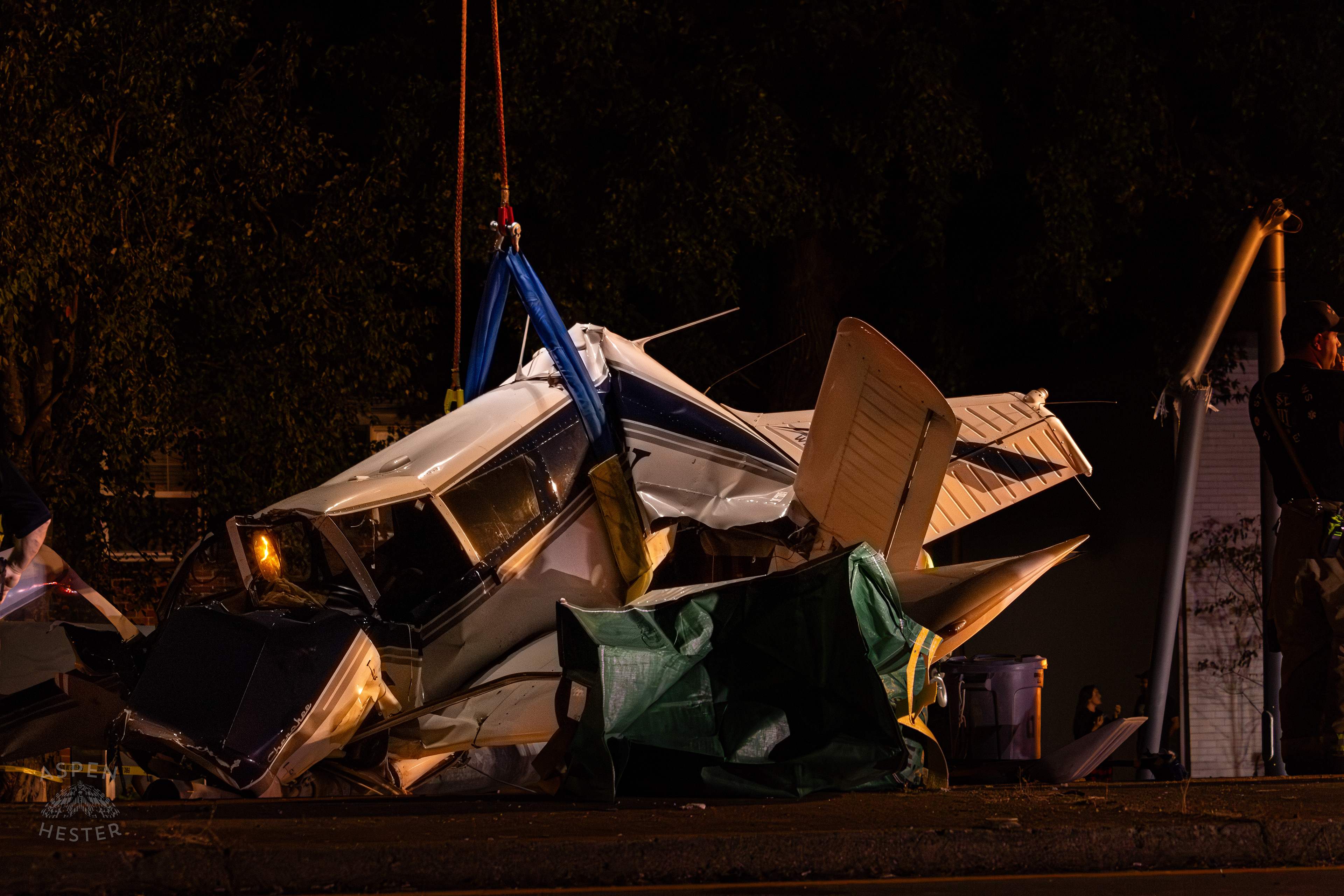 The Piper Cherokee Plane Being Lifted from the Road after it Crash Landed, Taking Out Utility Poles, and Hitting A Car on Breckenridge Lane and Kresge Way. October 11th, 2024/Aspen Hester 