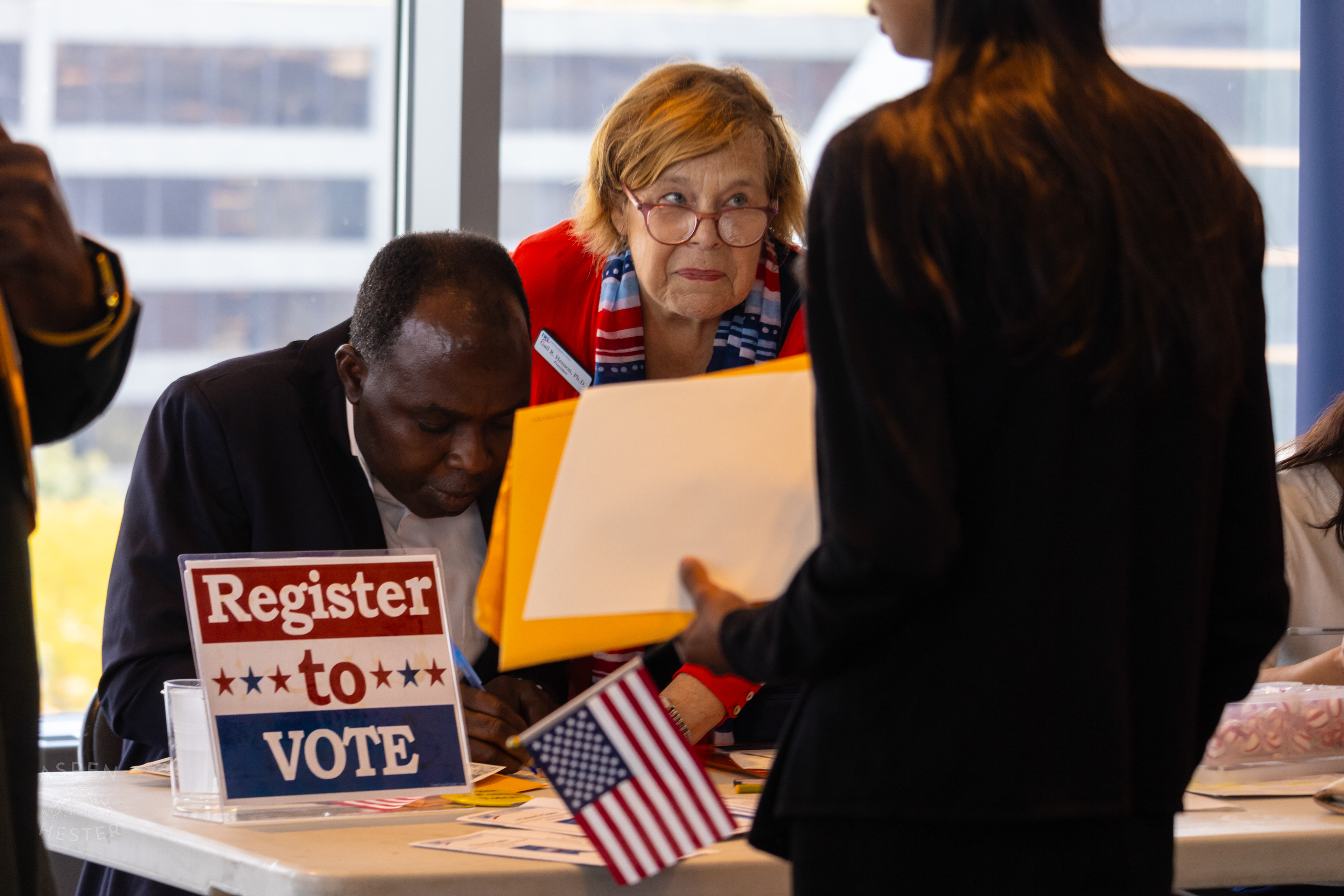 New American Citizen Registering to Vote with Help from The League of Women Voters After WorldFest's Naturalization Ceremony. August 30th, 2024/Aspen Hester