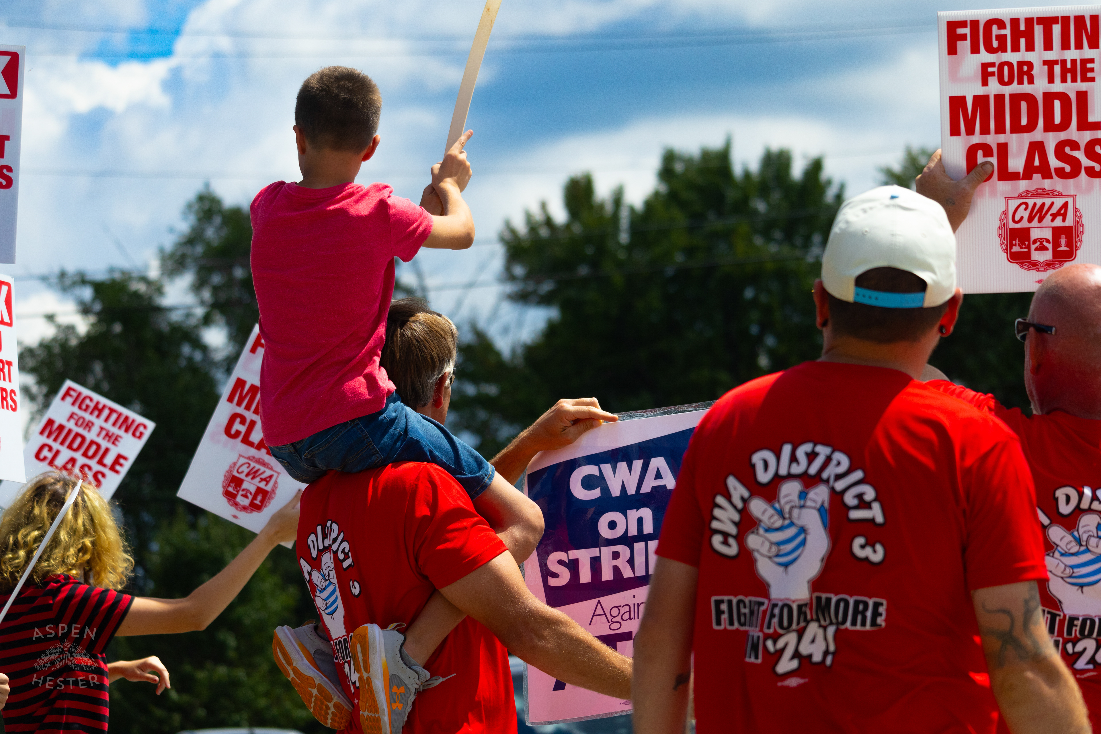 Member of The Communication Workers of America Union Hoists An Enthused Child onto Their Shoulders While Striking Against AT&T for Fair Pay and Benefits. August 18th, 2024/Aspen Hester