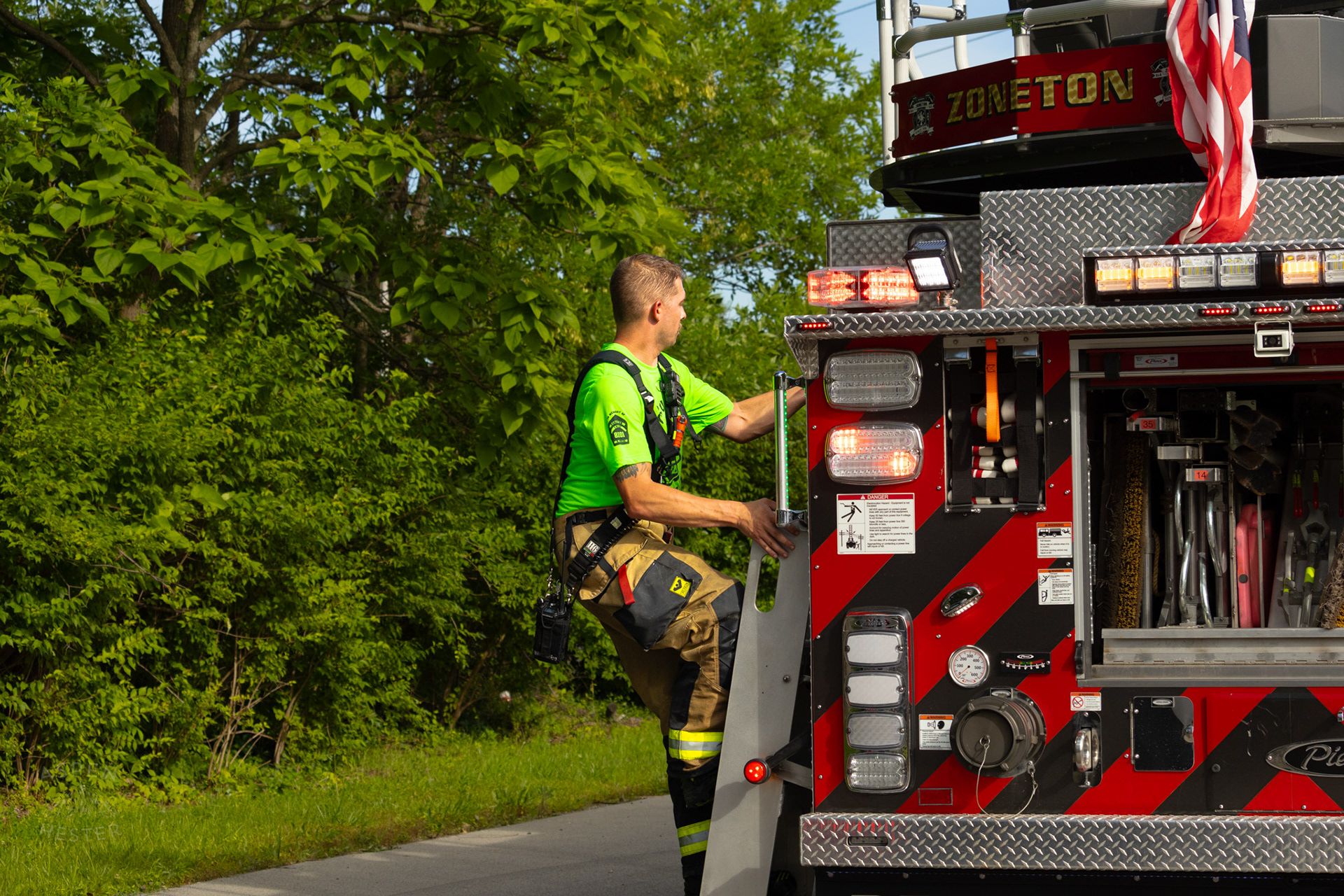 Zoneton Firefighter Climbing Aboard A Truck at The Old Library on Preston Highway. May 31st, 2024/Aspen Hester