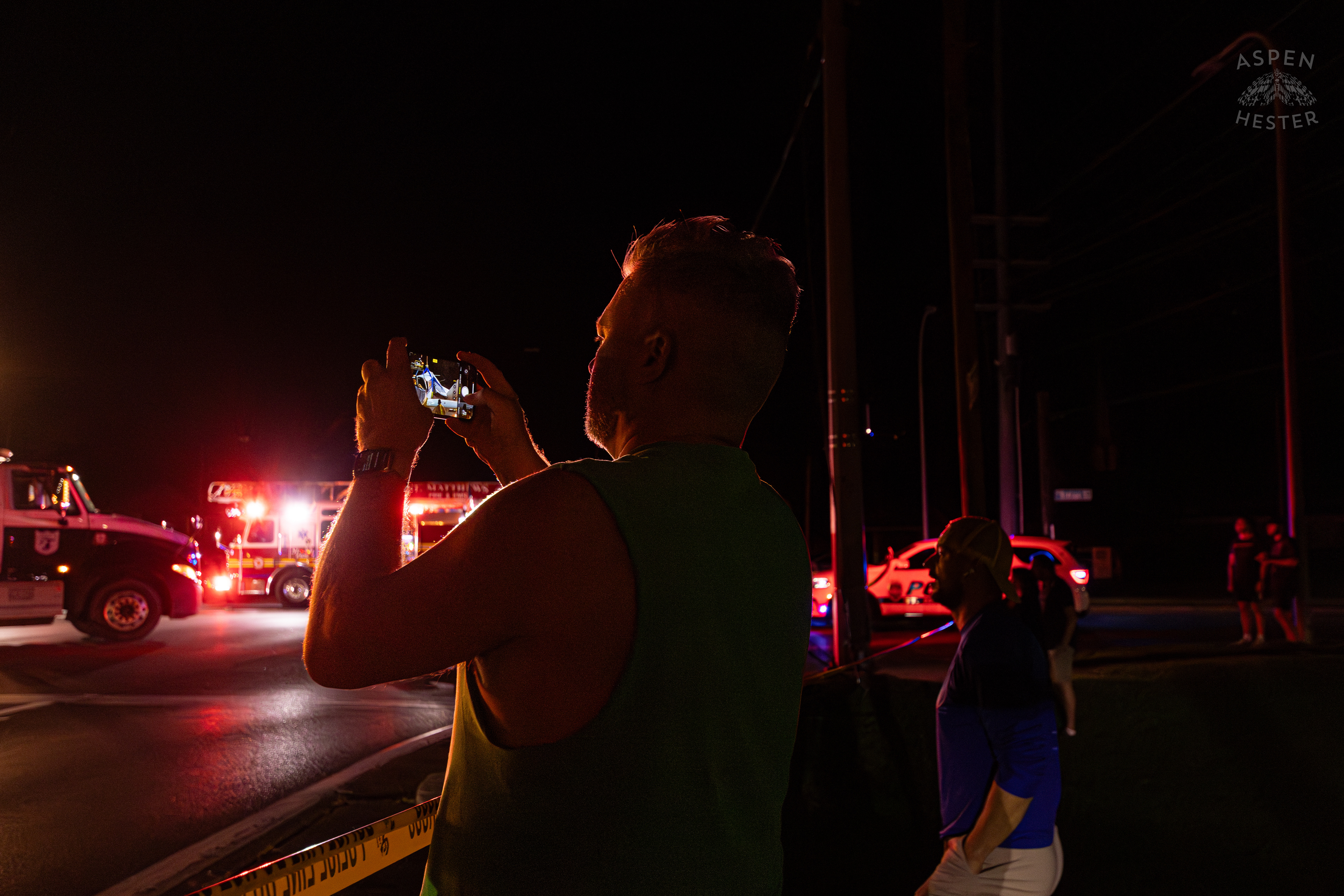 Onlookers Watching as Tony's Wreckers Crew Works to Remove The Piper Cherokee Plane from the Road after it Crash Landed, Taking Out Utility Poles, and Hitting A Car on Breckenridge Lane and Kresge Way. October 11th, 2024/Aspen Hester