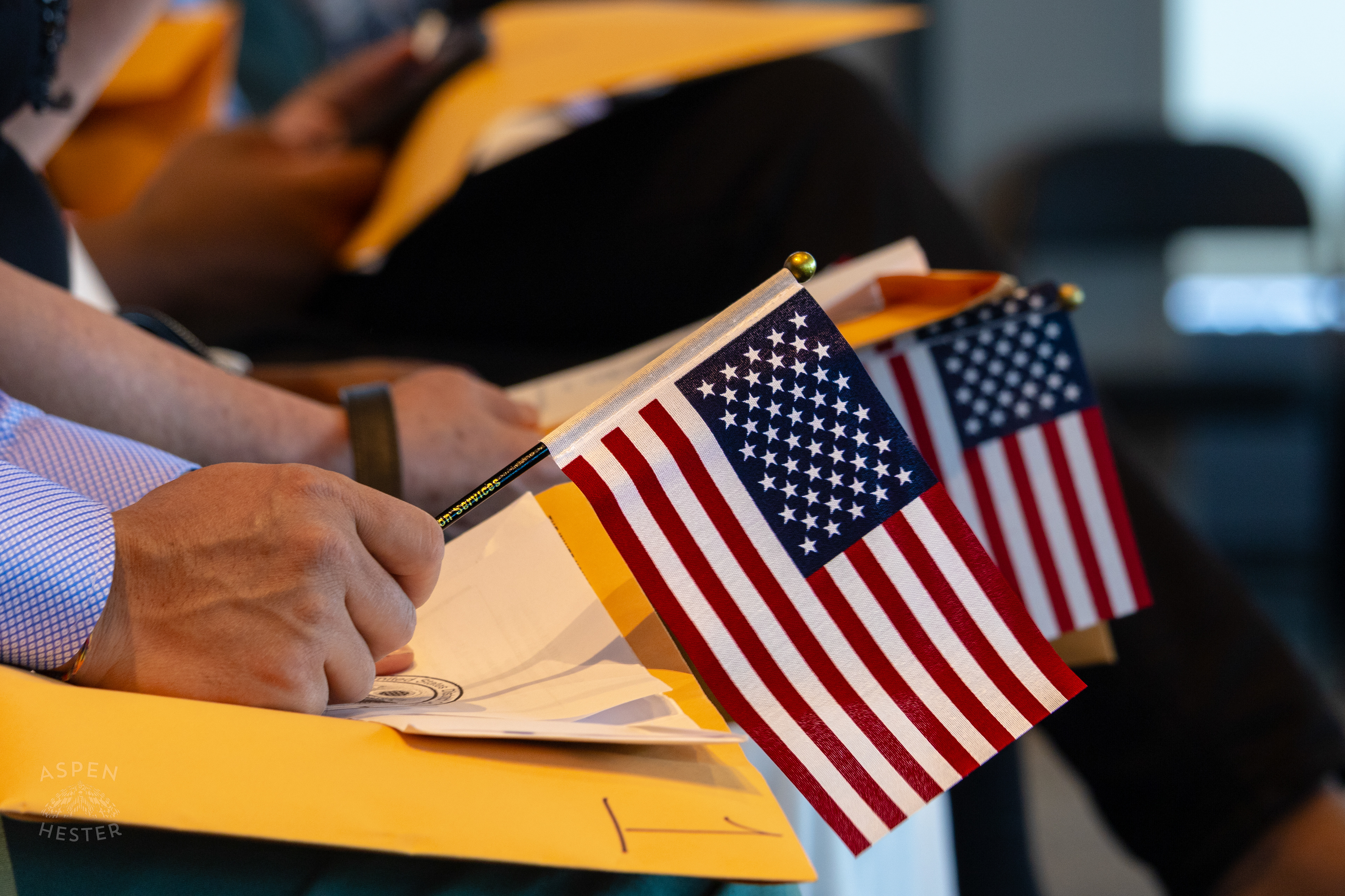 Migrants Holding American Flags at WorldFest's Naturalization Ceremony. August 30th, 2024/Aspen Hester