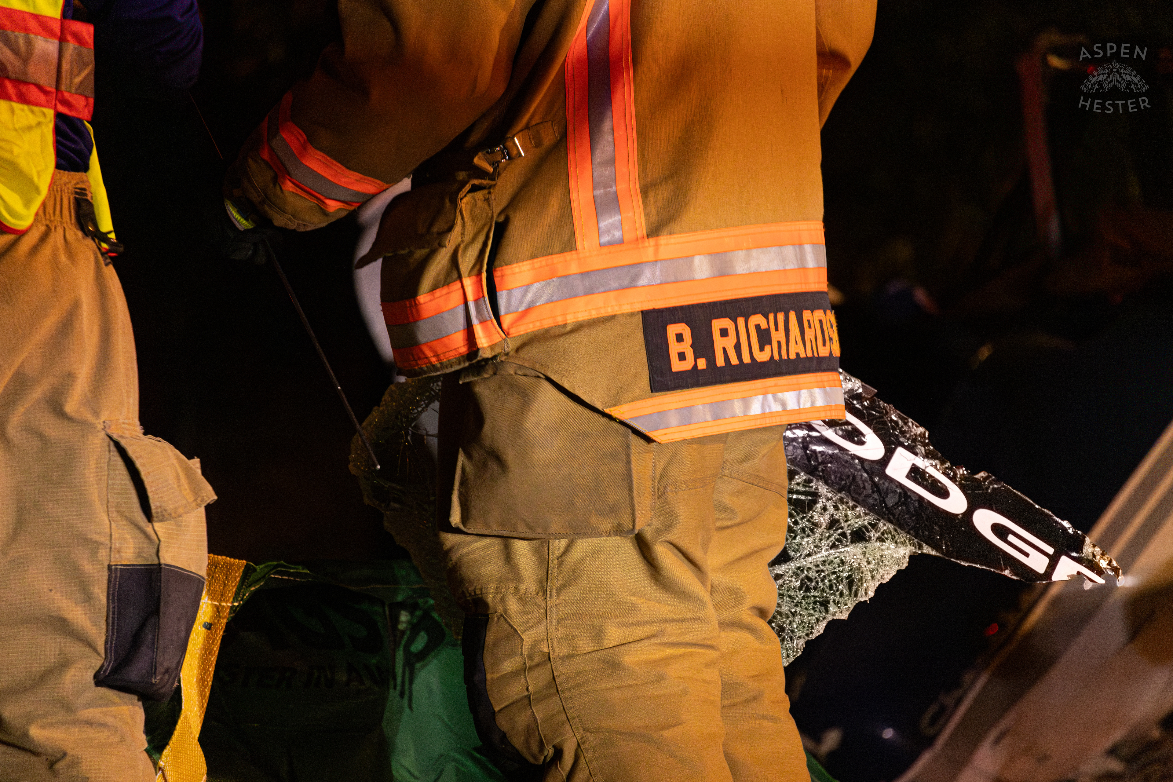 St. Matthews Firefighter Carrying A Piece of The Shattered Dodge Charger’s Windshield to The Debris Pile so A Crew from Tony’s Wreckers Can Begin Removing The Piper Cherokee Plane from the Road after it Crash Landed, Taking Out Utility Poles, and Hitting A Car on Breckenridge Lane and Kresge Way. October 11th, 2024/Aspen Hester 