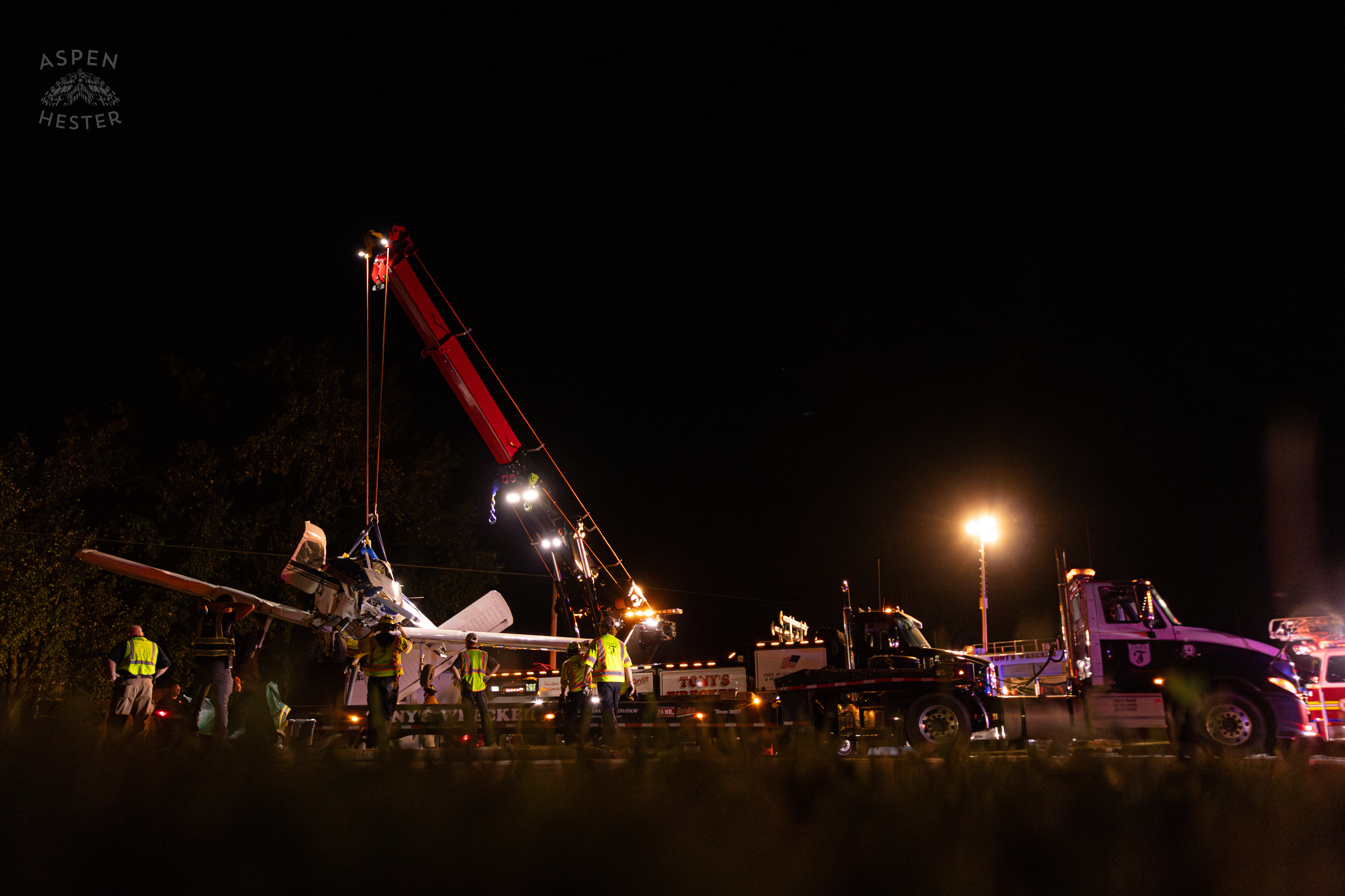 The Piper Cherokee Plane Being Lifted from the Road and Placed on A Flatbed Truck after it Crash Landed, Taking Out Utility Poles, and Hitting A Car on Breckenridge Lane and Kresge Way. October 11th, 2024/Aspen Hester 