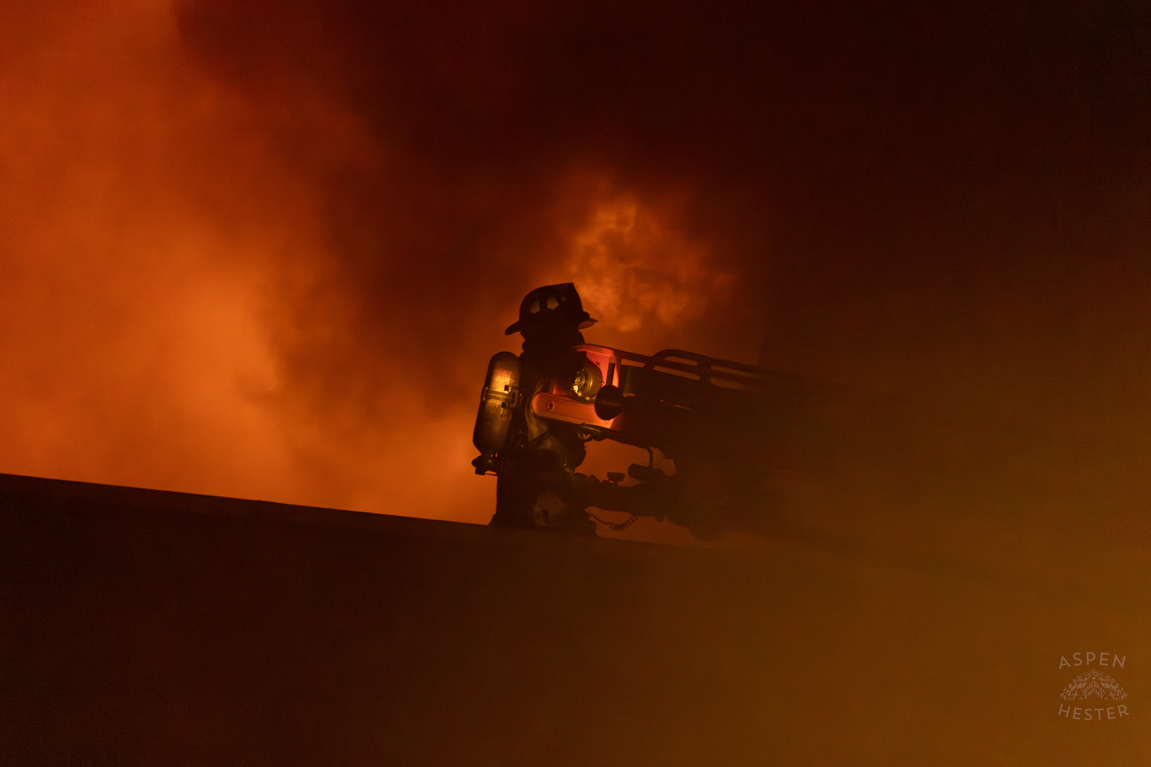 Firefighter Stands on A Nearby Roof In Front of The Massive 3 Alarm Blaze Engulfing The Vacant St. Paul's German Evangelical Church on East Broadway. October 9th, 2024/Aspen Hester
