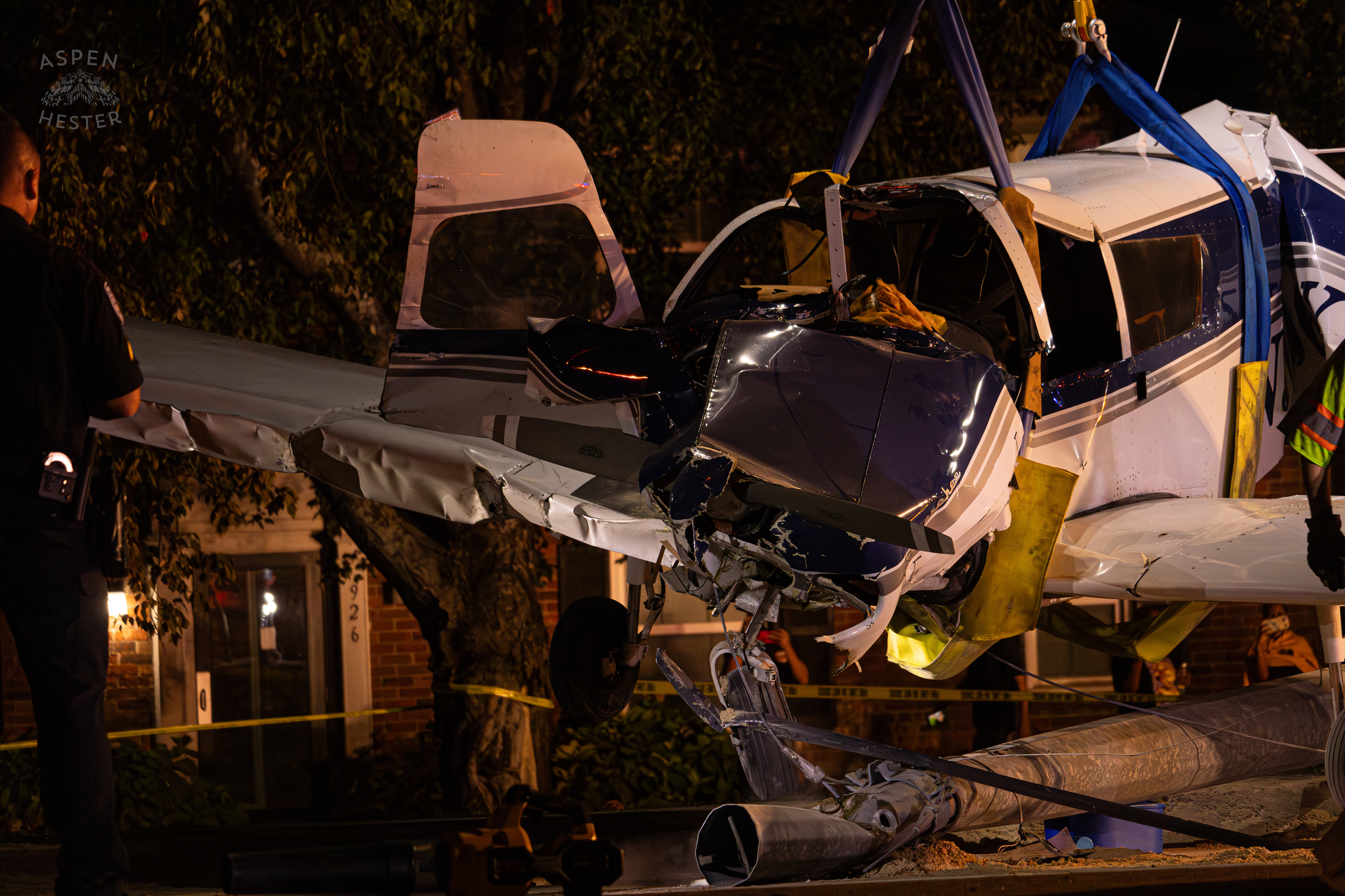 The Piper Cherokee Plane Being Lifted from the Road after it Crash Landed, Taking Out Utility Poles, and Hitting A Car on Breckenridge Lane and Kresge Way. October 11th, 2024/Aspen Hester 