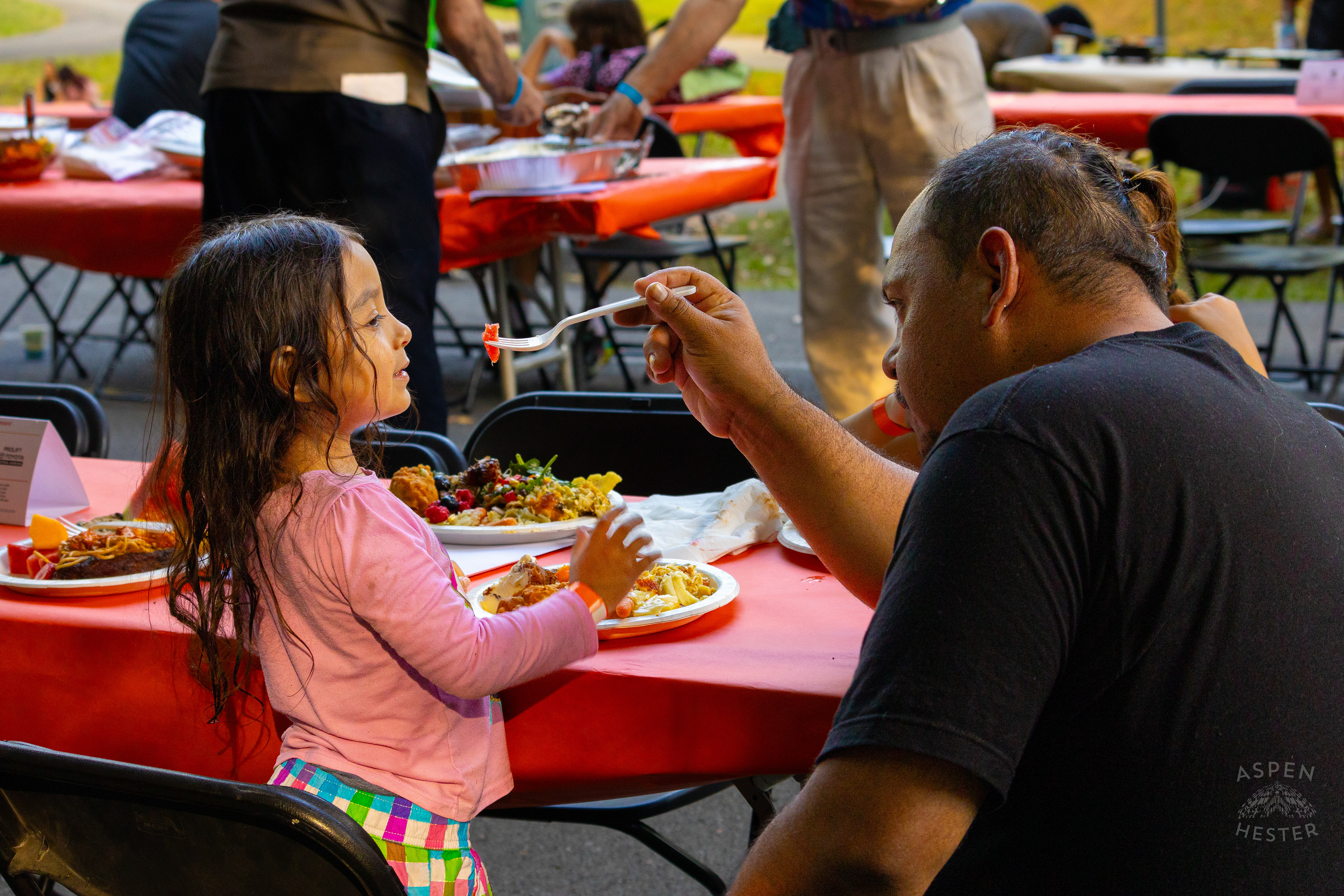 A Father Feeds His Young Daughter from The Big Table at Iroquois Park. September 15th, 2024/Aspen Hester