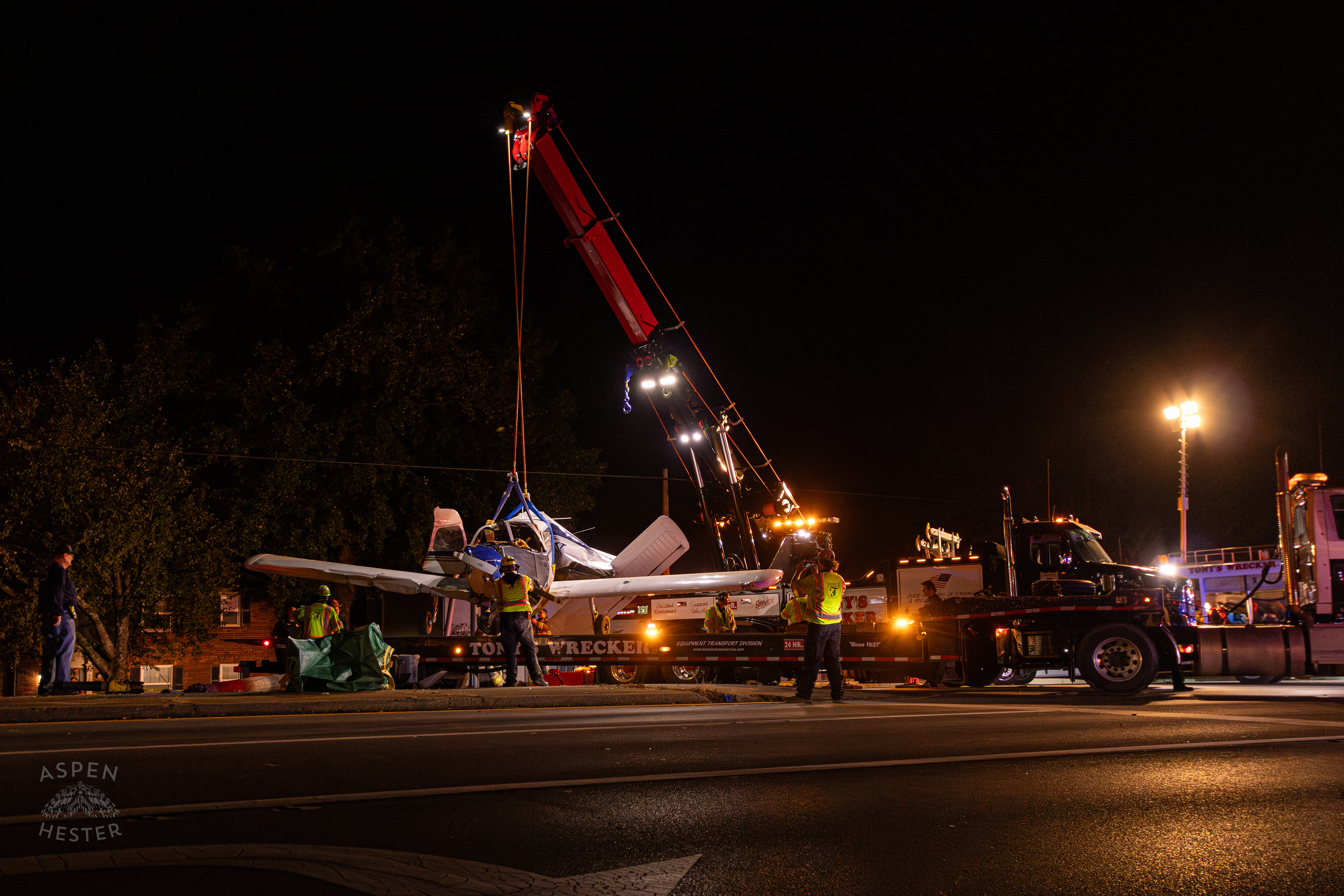 The Piper Cherokee Plane Being Lifted from the Road and Placed on A Flatbed Truck after it Crash Landed, Taking Out Utility Poles, and Hitting A Car on Breckenridge Lane and Kresge Way. October 11th, 2024/Aspen Hester 