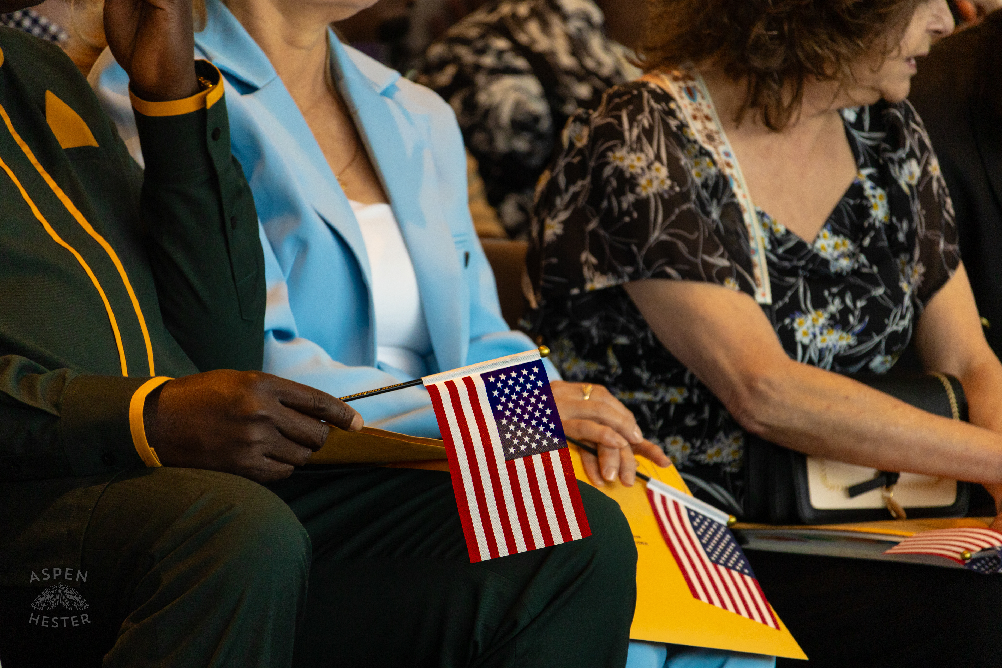 Migrants Holding American Flags at WorldFest's Naturalization Ceremony. August 30th, 2024/Aspen Hester