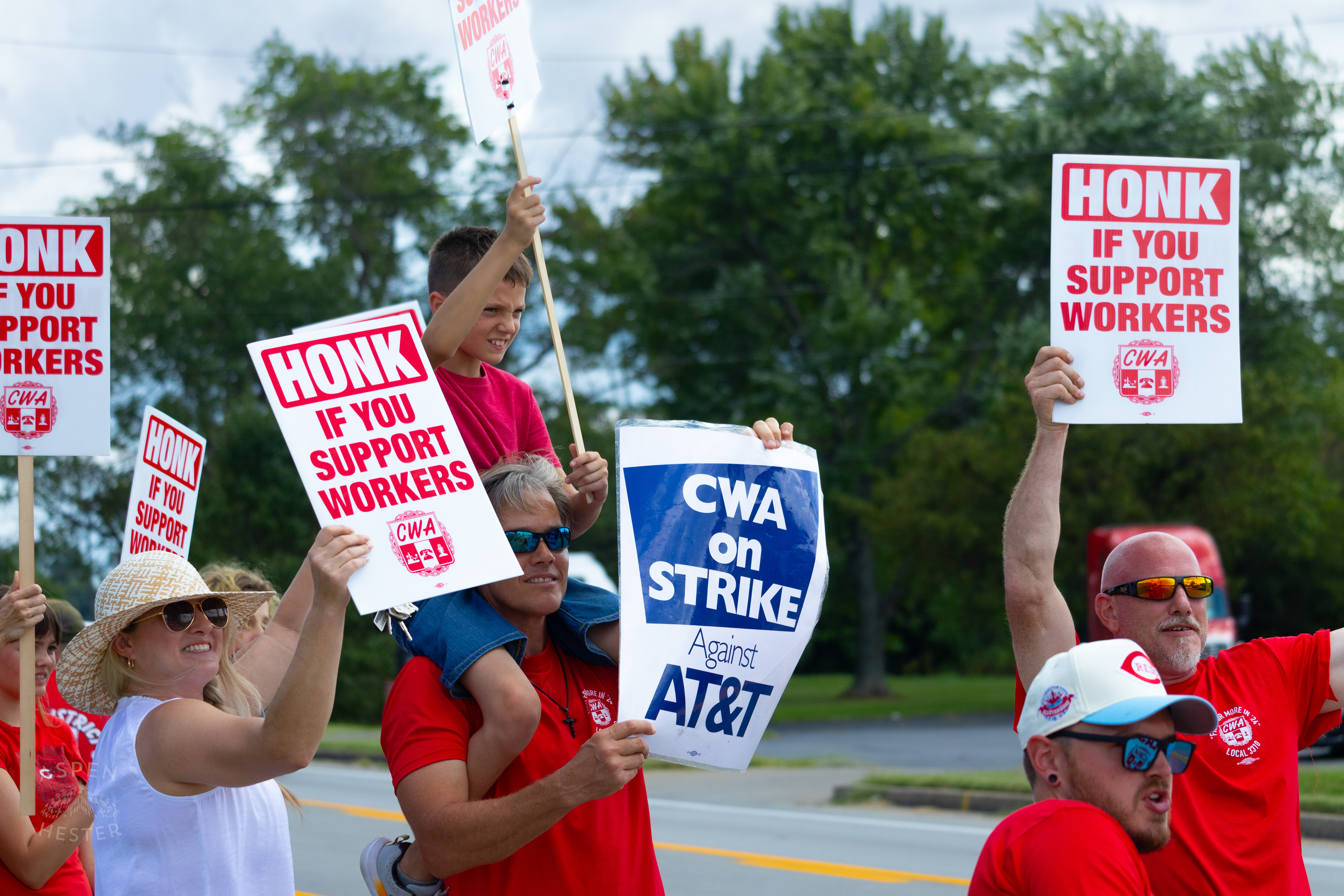 Member of The Communication Workers of America Union Hoists An Enthused Child onto Their Shoulders While Striking Against AT&T for Fair Pay and Benefits. August 18th, 2024/Aspen Hester