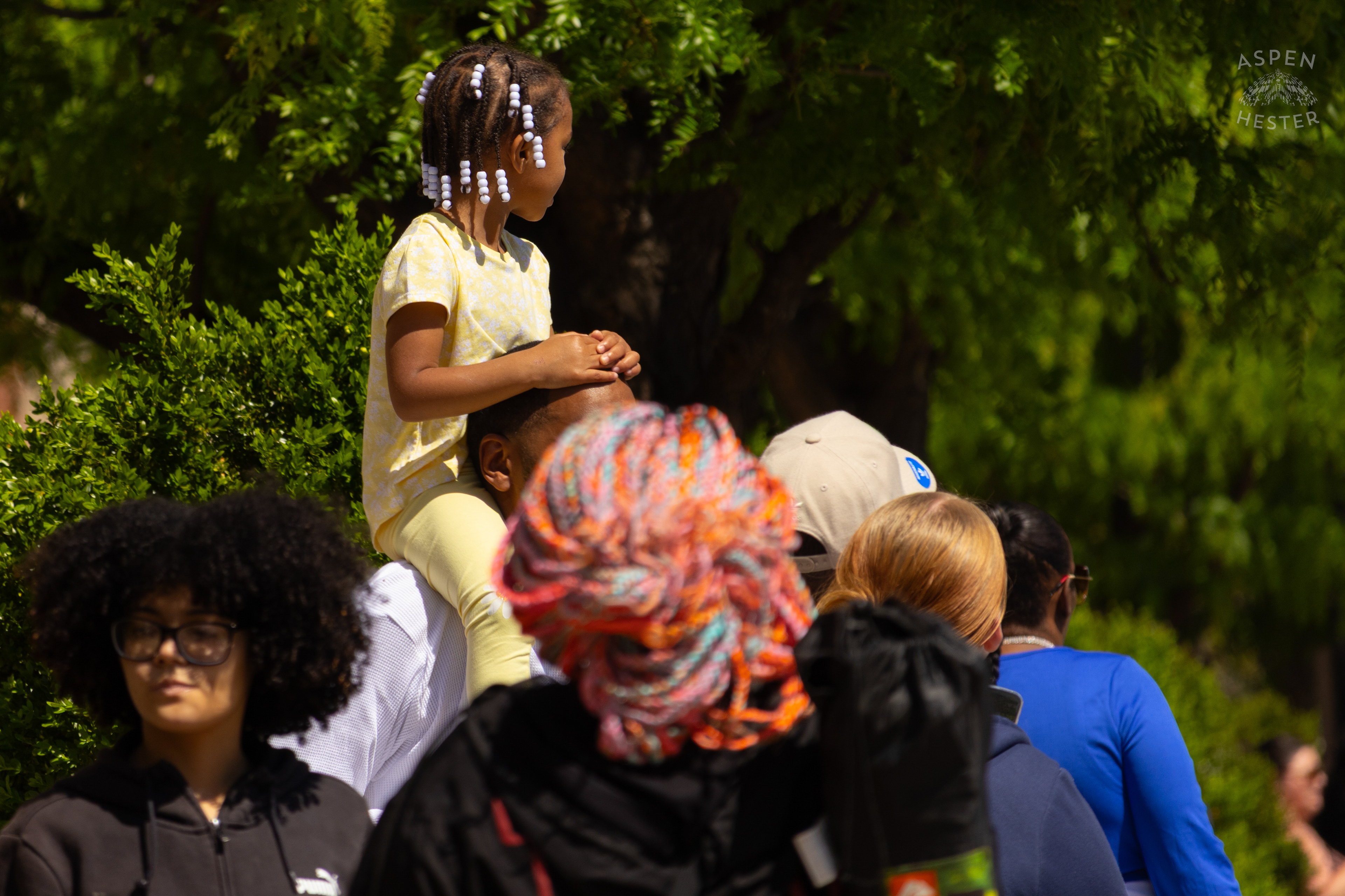 Children Watch The 70th Annual Pegasus Parade From Their Parents' Shoulders. April 27th, 2025/Aspen Hester