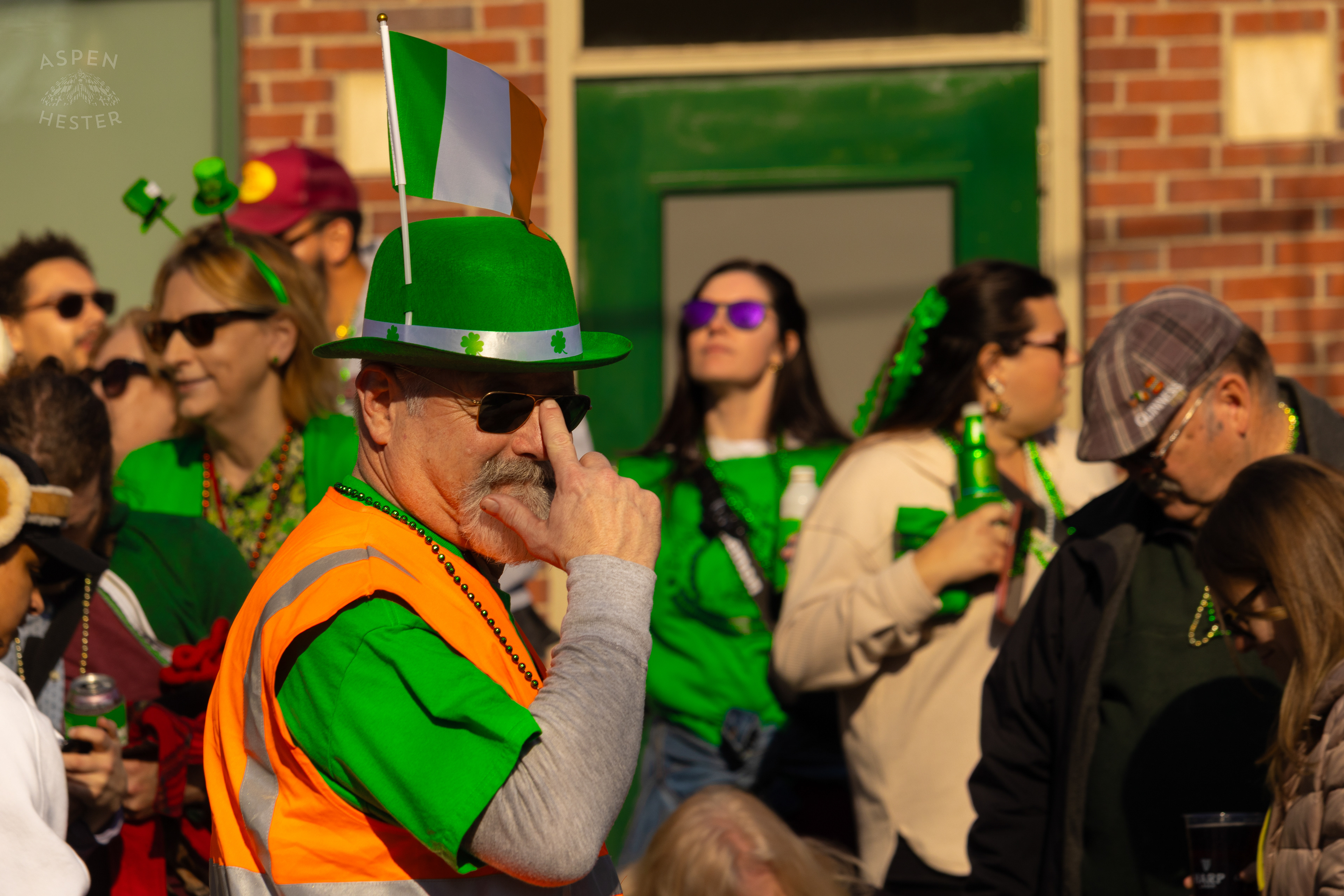 A Security Guard with An Irish Flag in Their Hat Walks Along as The 52nd Annual Saint Patrick’s Day Parade Rolls Through The Highlands. March 8th, 2025/Aspen Hester