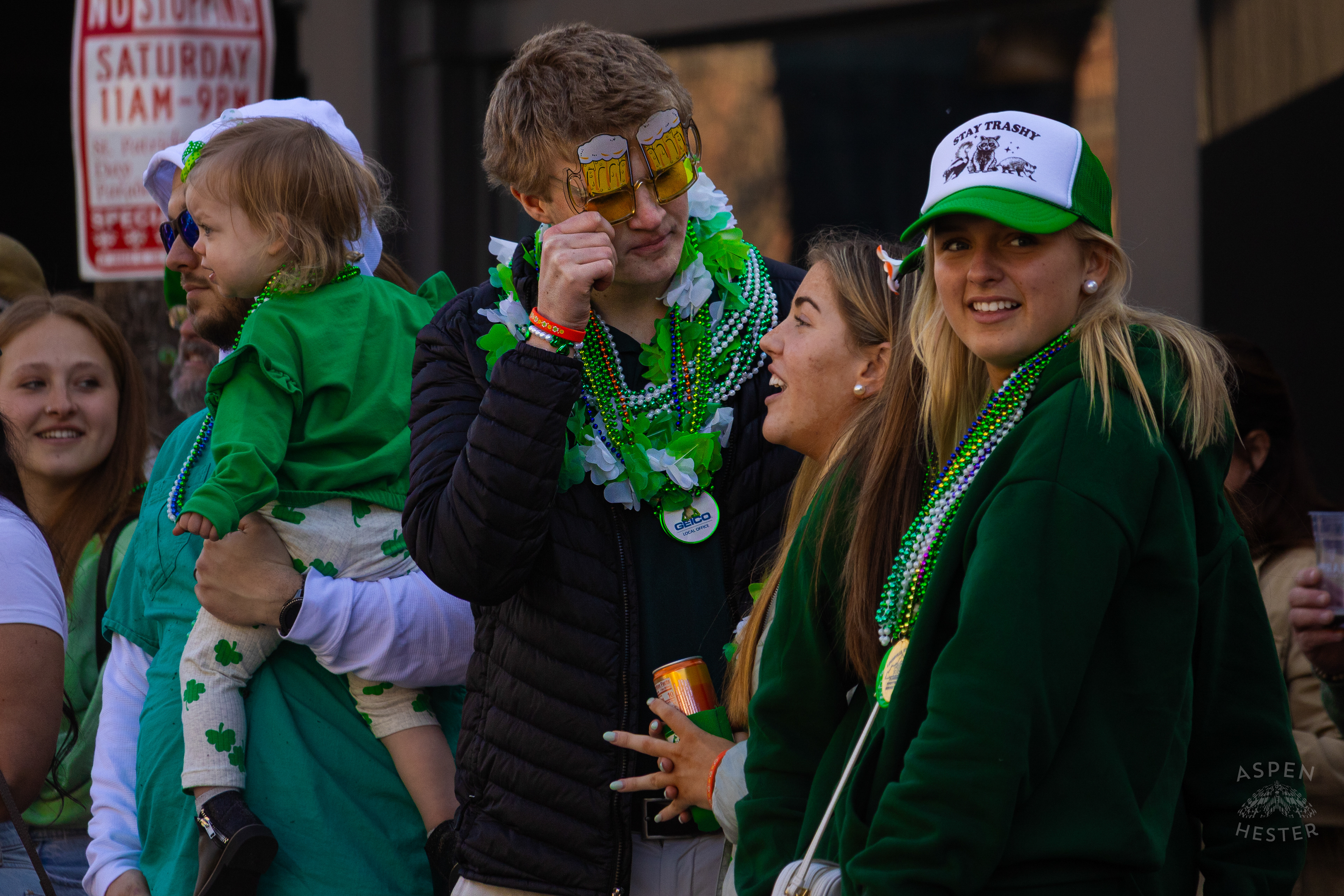 A Spectator Decked Out in Beads and Beer Glasses Watches as The 52nd Annual Saint Patrick’s Day Parade Rolls Through The Highlands. March 8th, 2025/Aspen Hester