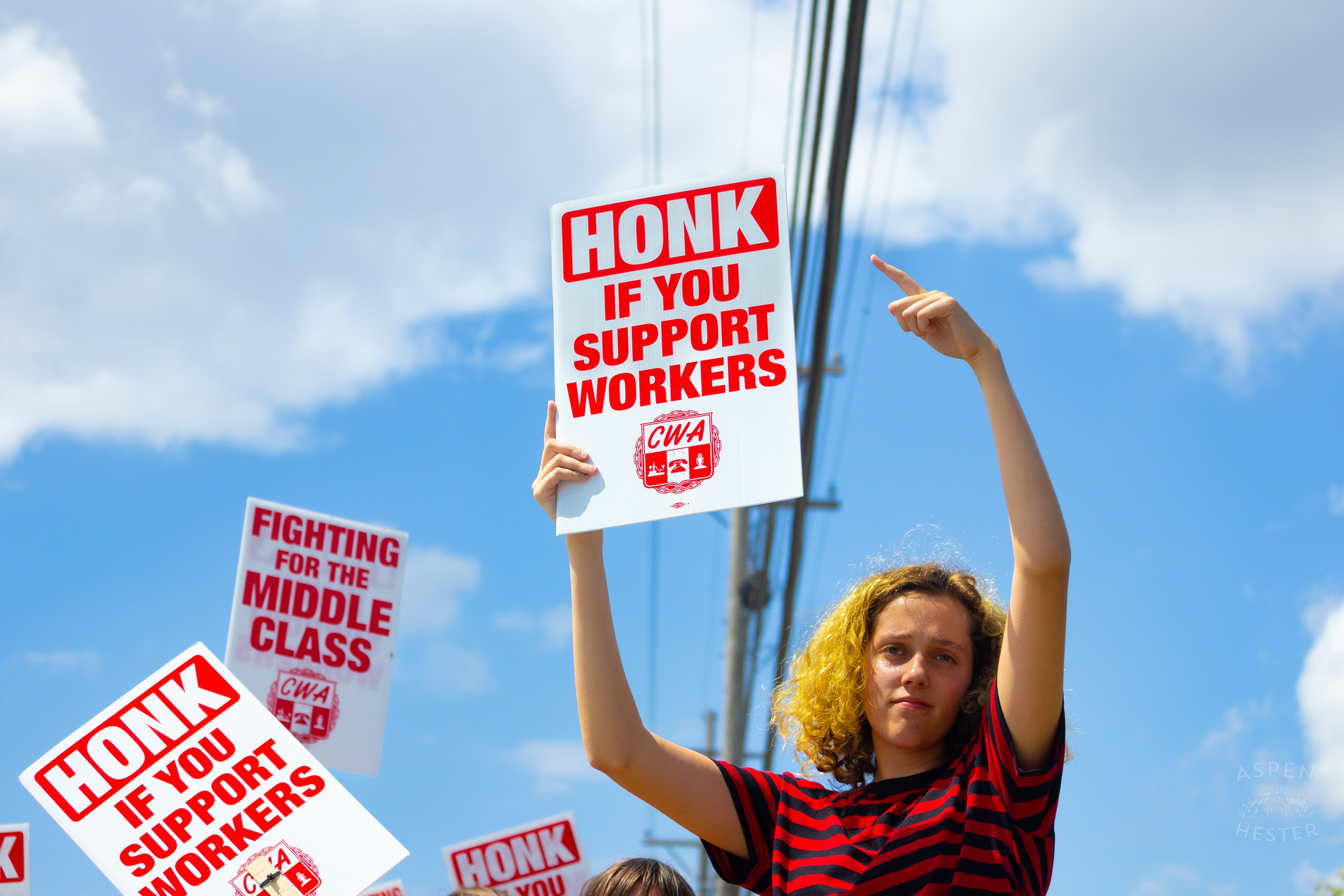 Picketer Encourages Cars to Honk in Support of The Communication Workers of America Union Strike Against AT&T for Fair Pay and Benefits. August 18th, 2024/Aspen Hester