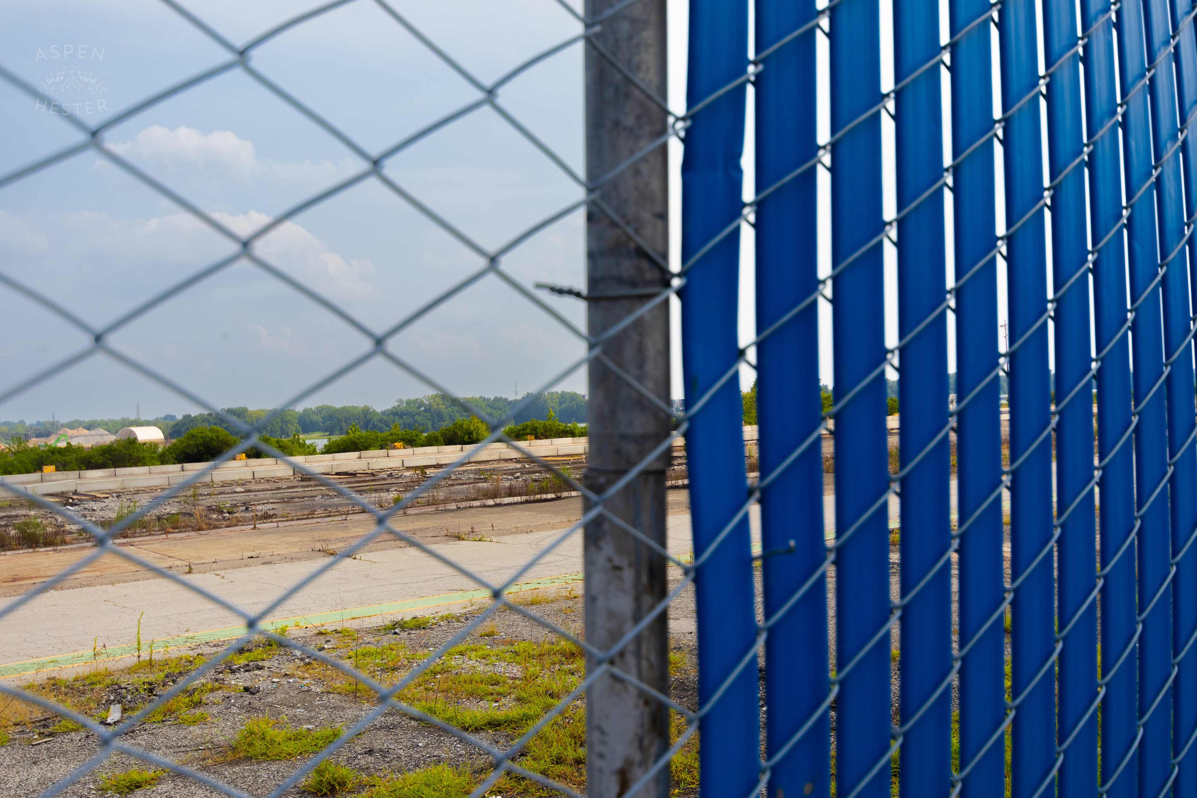 Looking Through the Chain Link Fence and Blue Tarp at the Abandoned Jeffboat Shipyard. July 26th, 2024/Aspen Hester