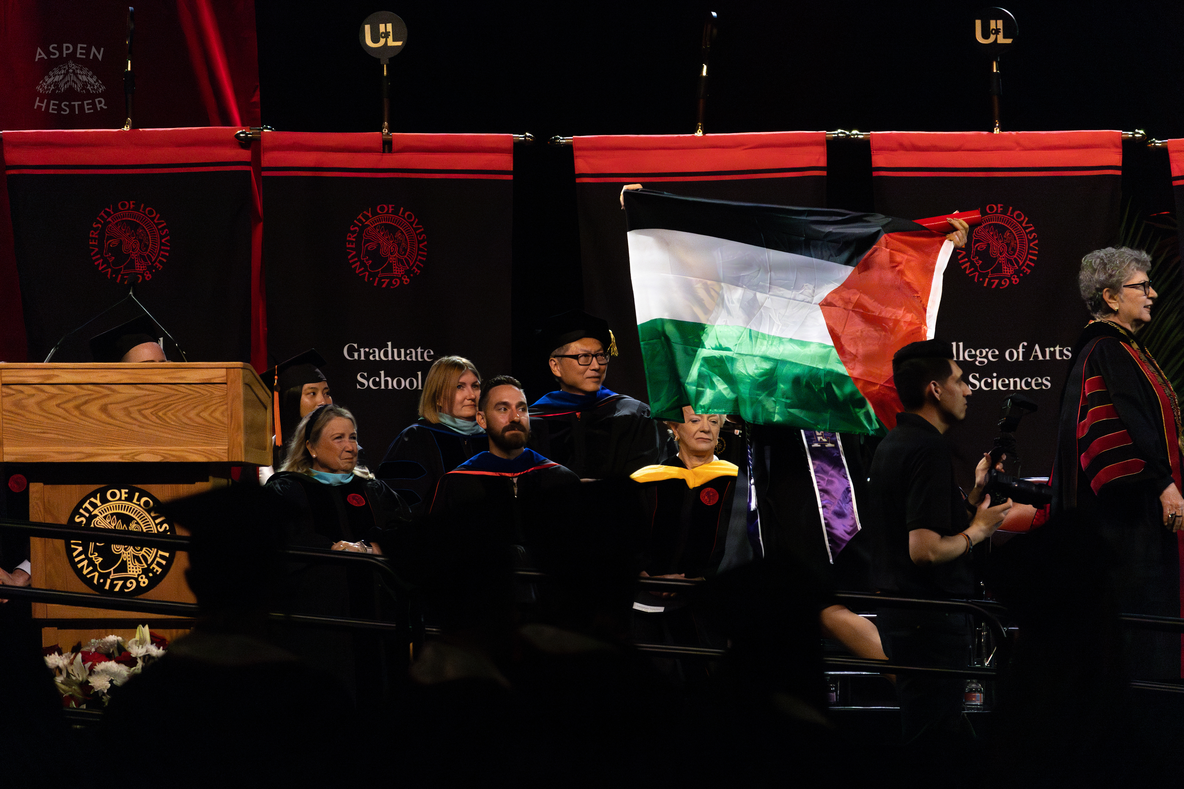 Student Flies The Palestinian Flag as They Walk Across The Stage at UofL's 2024 Spring Graduation. May 11th, 2024/Aspen Hester