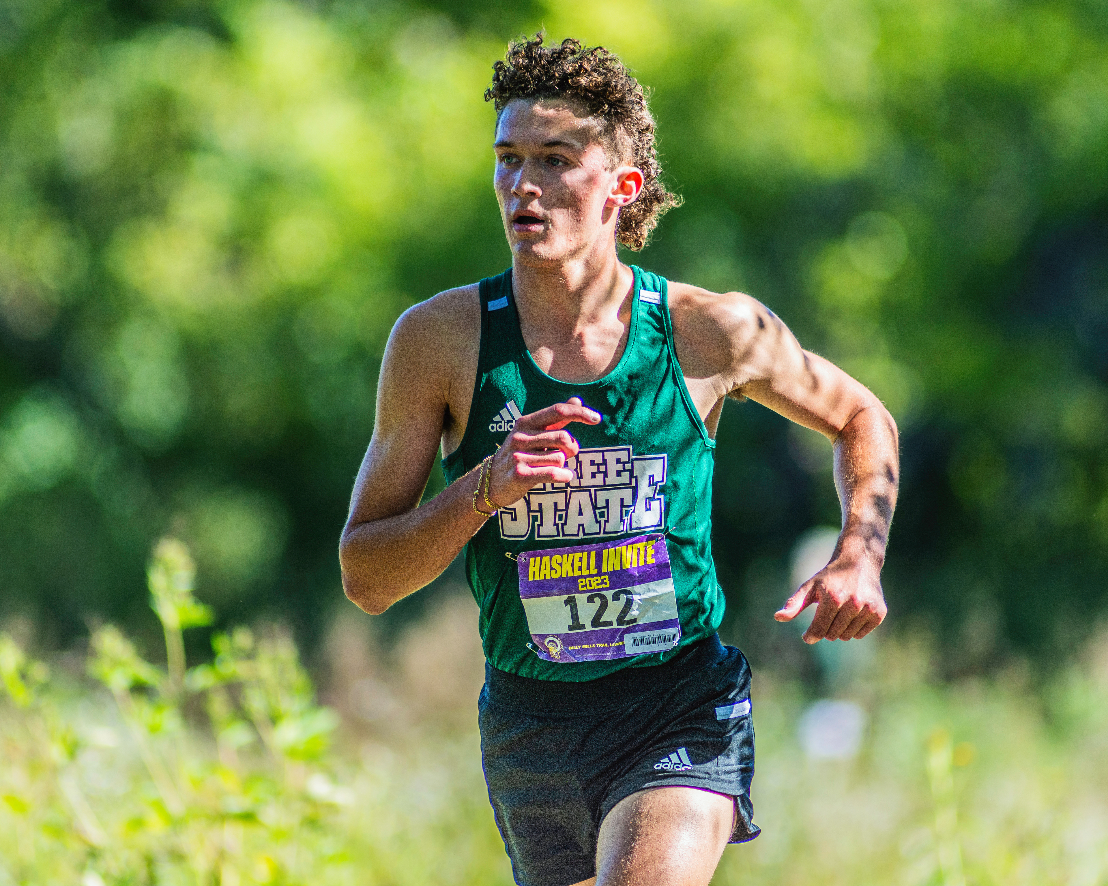 Racing to the end of the season: Running through the trees at the Haskell Invitational cross country meet, senior Jake Hedges runs the 5-mile on Oct. 7. Hedges has been a part of the Free State cross country team for three years, and is now in his senior season. “It’s been such a big part of my high school socially, and physically, so it’s definitely crazy that it’s finally coming to an end,” Hedges said.