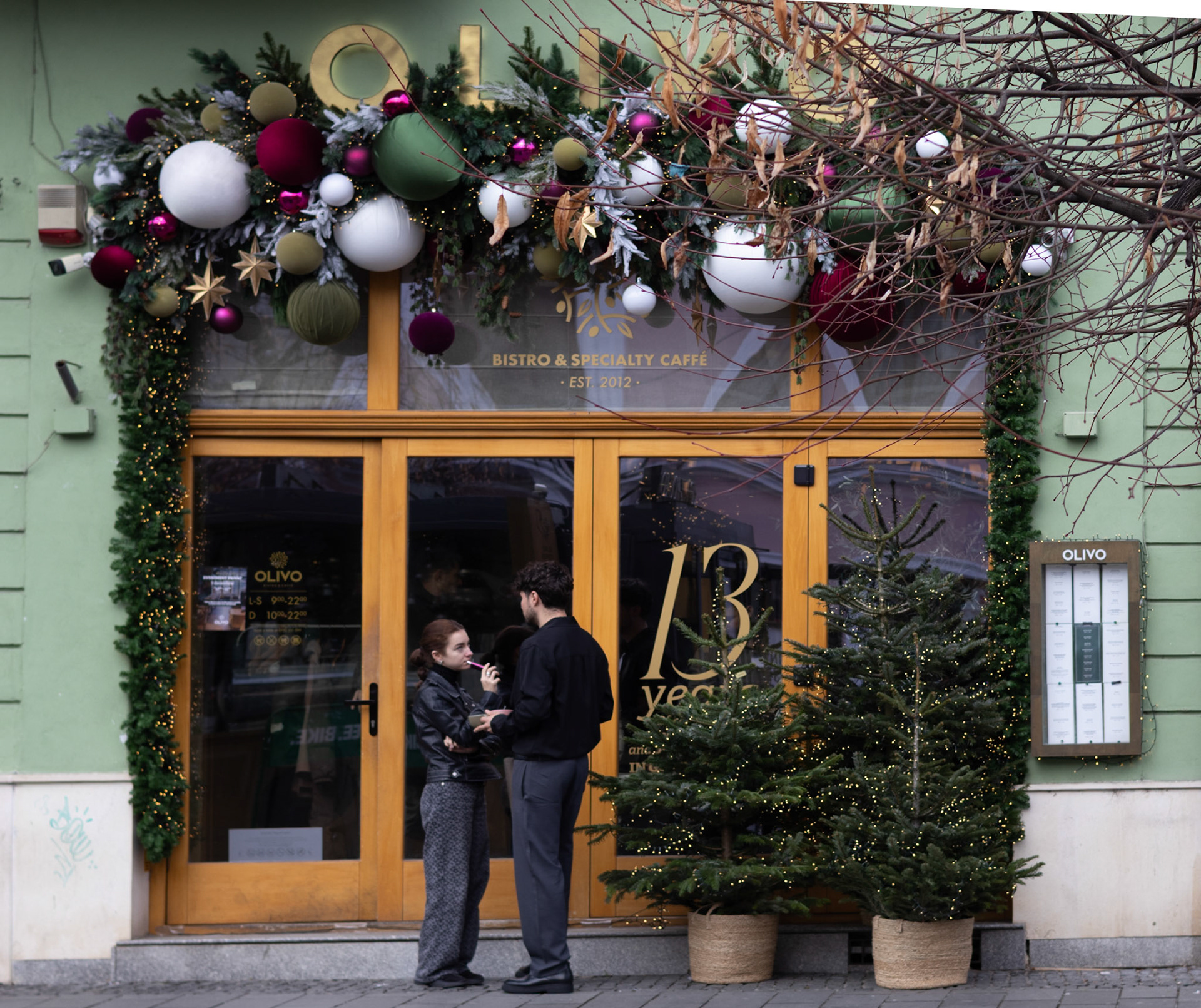 Doi tineri stând de vorbă în fața unei cafenele, pe Eroilor, în Cluj-Napoca.