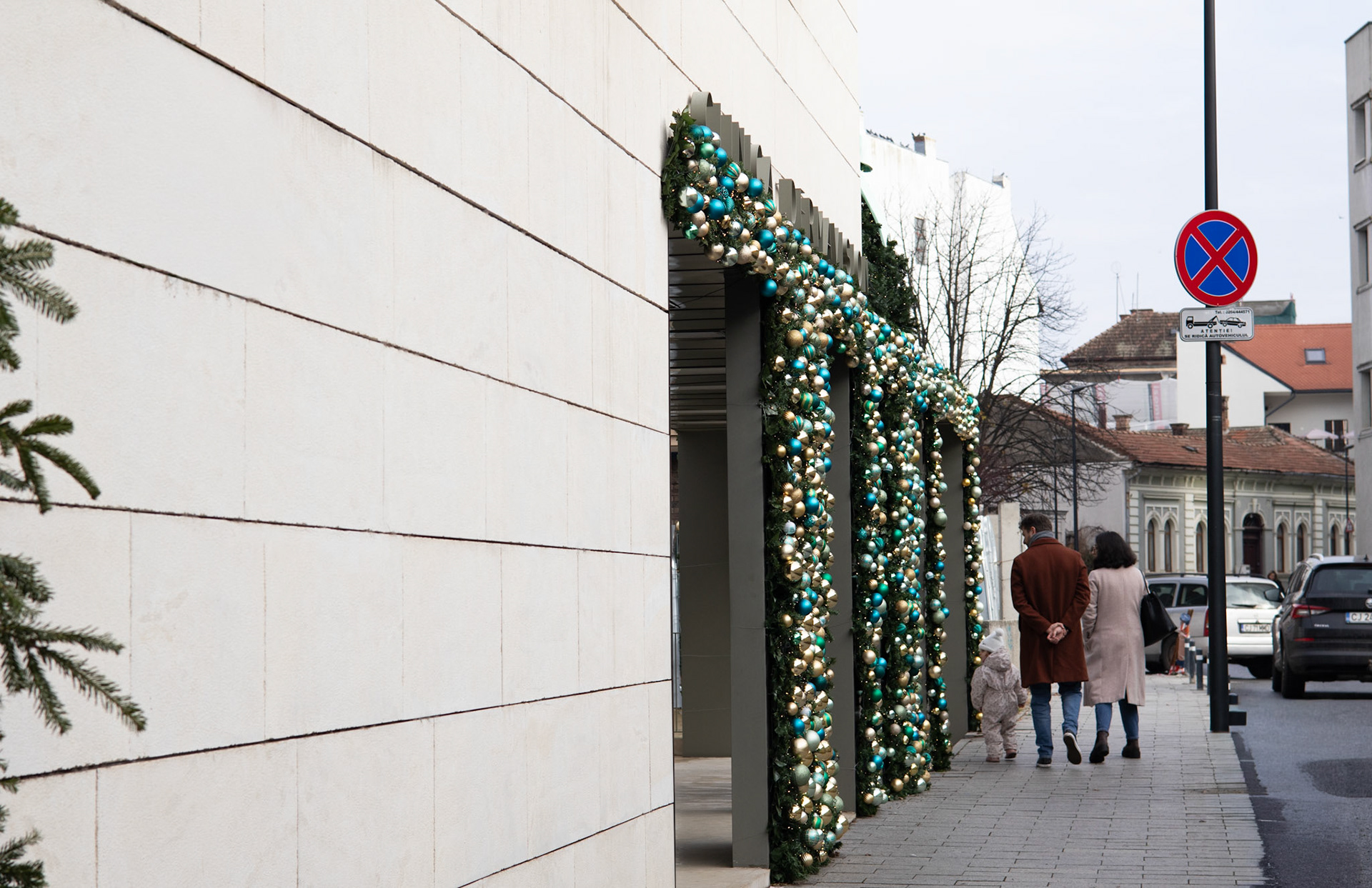 O familie admiră fațada decorată de sărbători, pe strada Sindicatelor din Cluj-Napoca.