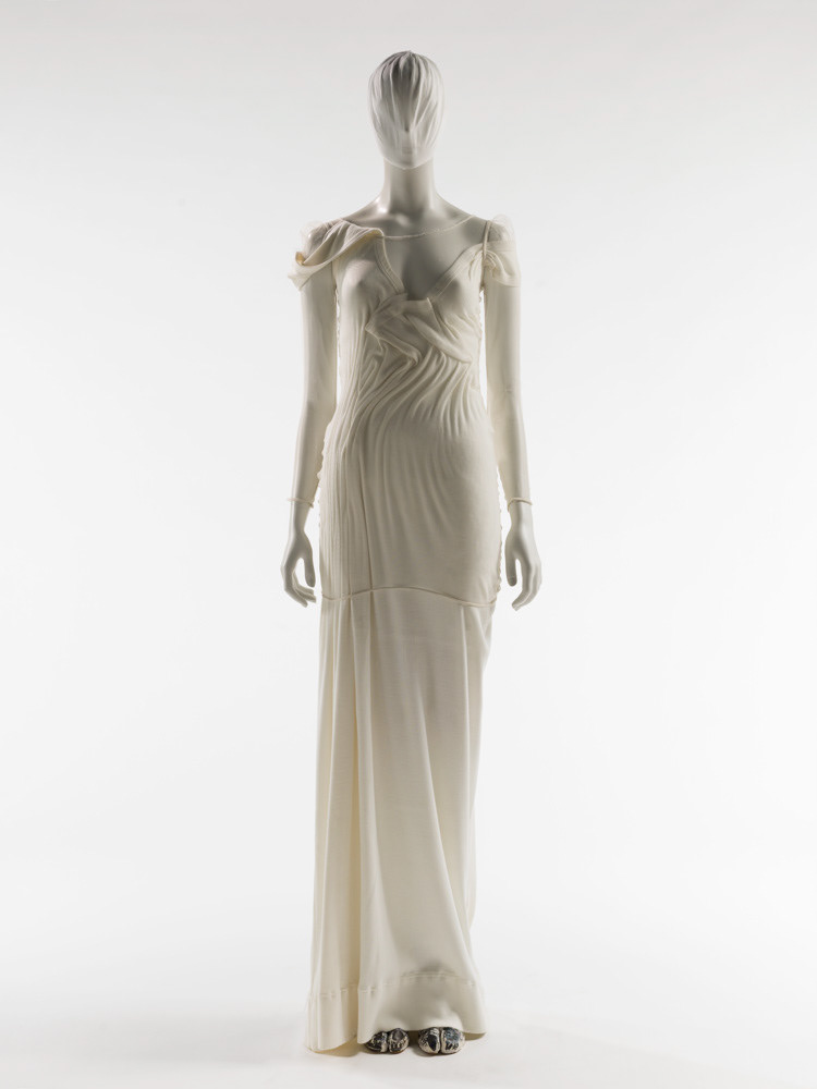 Martin Margiela (né en 1957). Tee-shirt en résille, "Marcel géant", ceinture et paire de tabis graffitées. Résille de Nylon. Jersey à côtes de coton blanc. Métal, gros-grain et bolduc en coton. Veau velours peint blanc. Feutre noir, gris et bleu foncé. Printemps-été 1990. Galliera, musée de la Mode de la Ville de Paris. © Julien vidal / Roger-Viollet