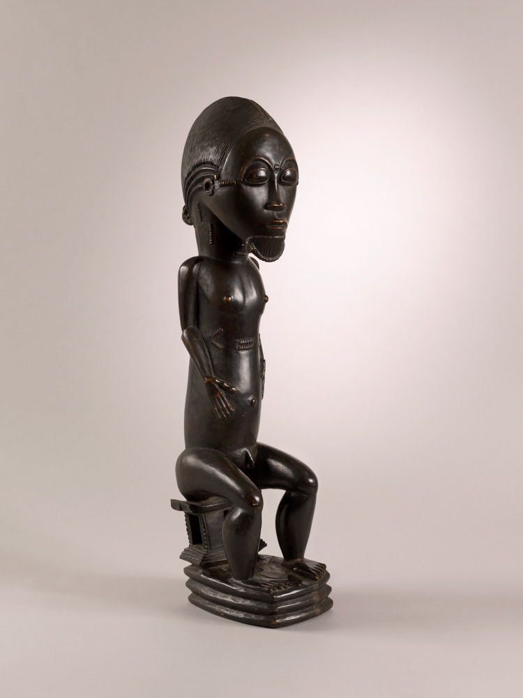 Anonyme (Côte d'Ivoire, Baoulé). "Personnage masculin assis sur un siège à quatre montants sculptés". Bois, patine foncée et brillante. 1900. Paris, musée d'Art moderne. © Julien vidal / Roger-Viollet