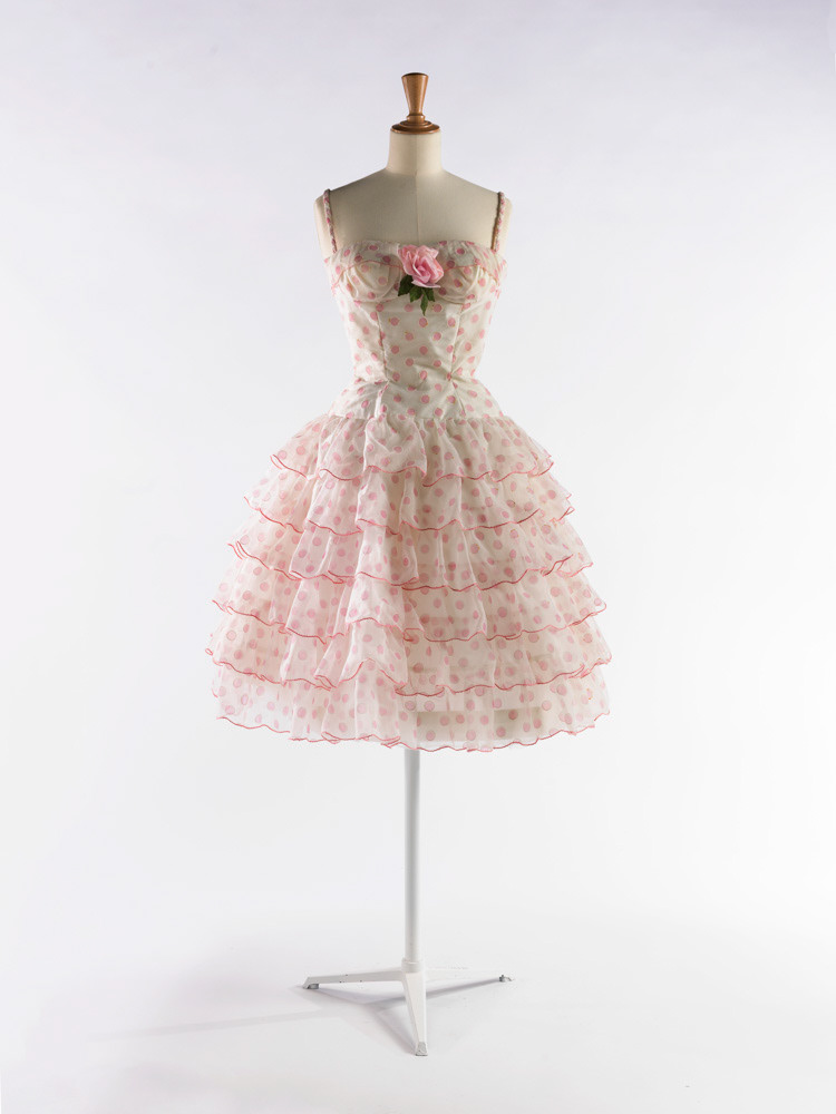 Garde-robe de Dalida. Anonyme. Robe. Voile de fibres artificielles blanc à décor de cercles en plumetis blancs réimprimés de pastilles rose. Ganses de fils de soie roses surfilés de blancs. Taffetas de Nylon. Taffetas de viscose. Fermeture à glissière métallique. 1957-1959. Galliera, musée de la Mode de la Ville de Paris. © Julien vidal / Roger-Viollet