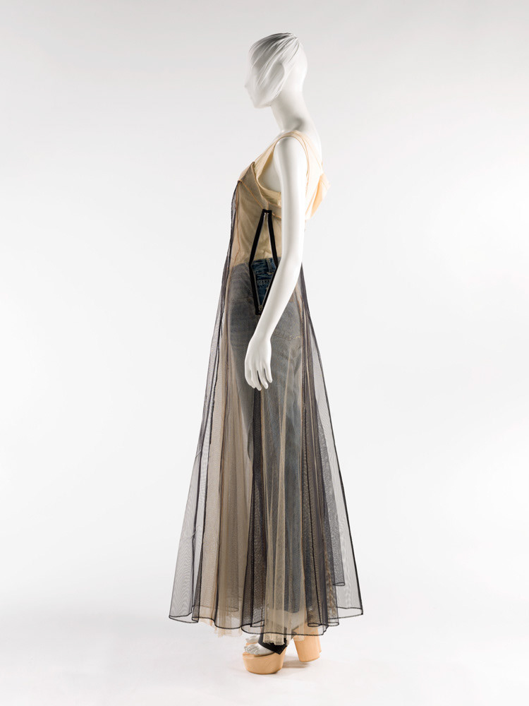 Martin Margiela (né en 1957). Robe à double tulle, Marcel à pinces porté en robe, jean et paire de sandales tabi. Double tulle polyester. Jersey de viscose. Cuir agrafé, bois et gomme. Printemps-été 1991. Galliera, musée de la Mode de la Ville de Paris. © Julien vidal / Roger-Viollet