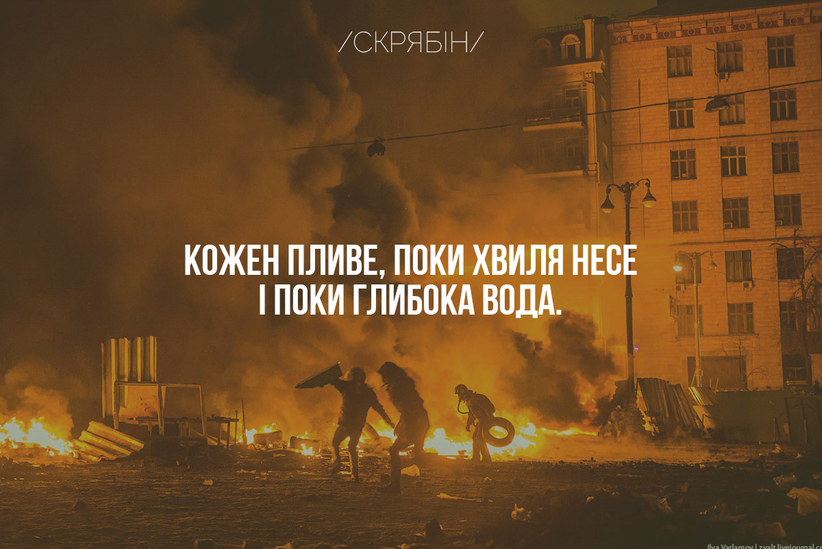 The state coat of arms of Ukraine, Tryzub, against background Dynamivska str barricades on fire. Euromaidan Protests. Events of Jan 19, 2014.