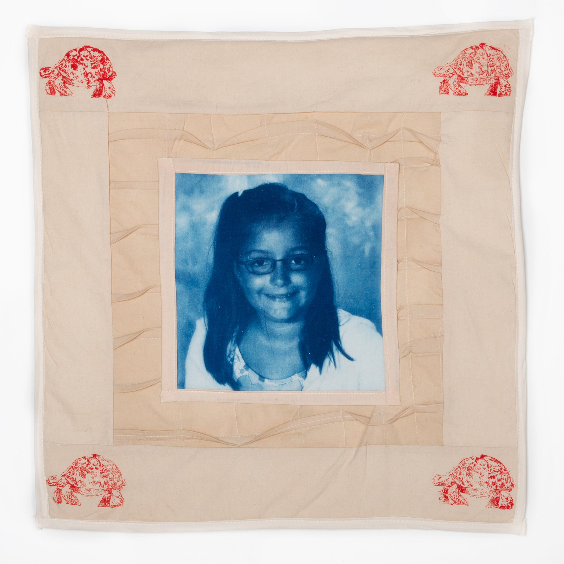 Cotton cyanotype print, machine quilted, cotton fabrics dyed with tea and coffee, cotton batting, and laser-etched stamp. 17.5" x 17.5"