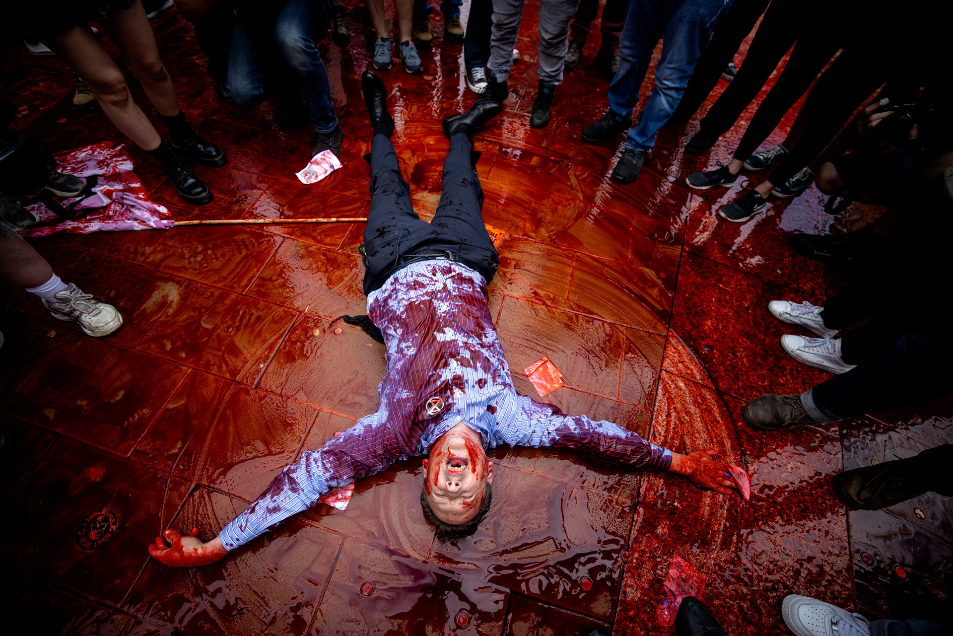 A climate activist from the Extinction Rebellion group lies down in fake blood smeared on the floor of Paternoster Square