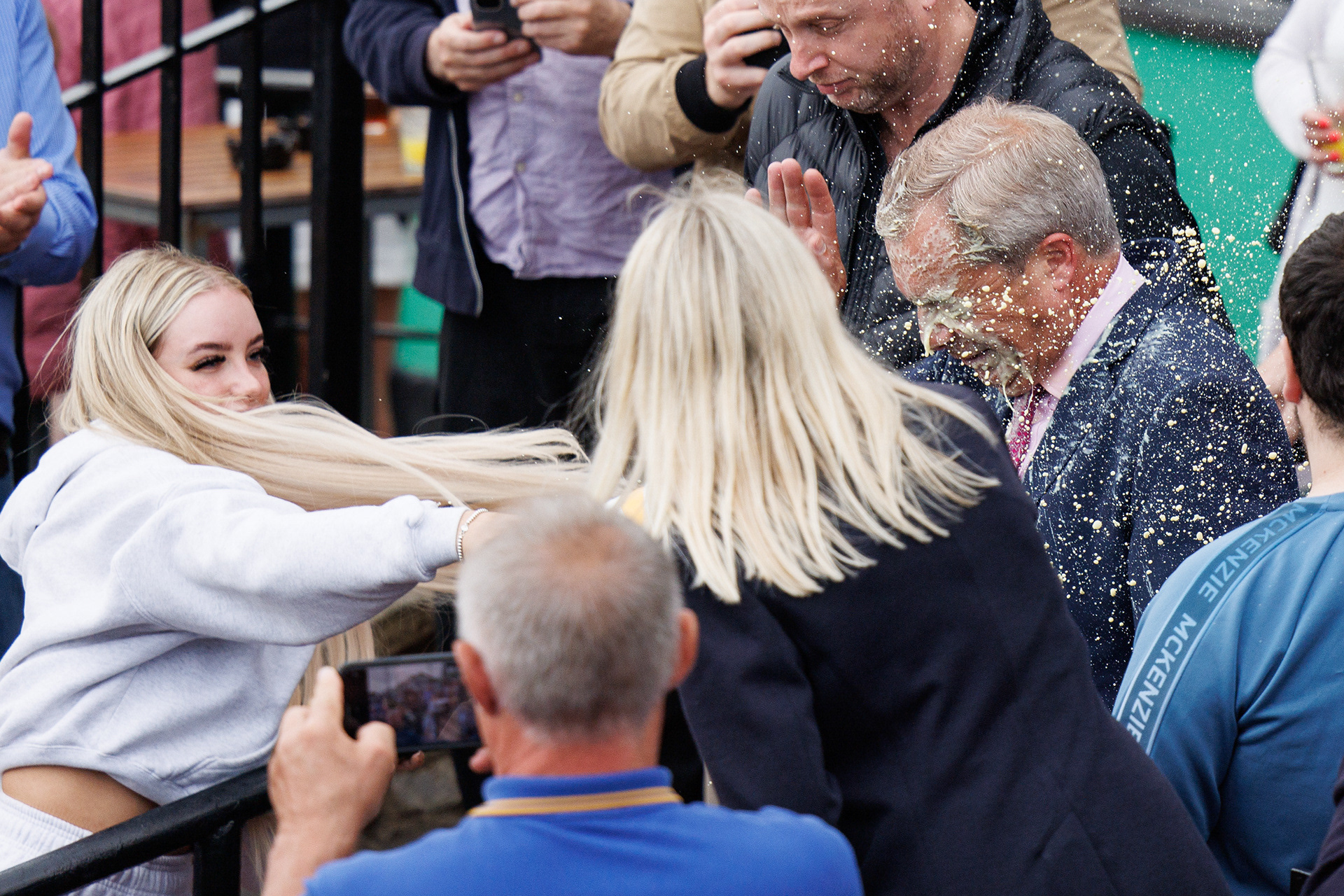 A woman throws a milkshake at Nigel Farage