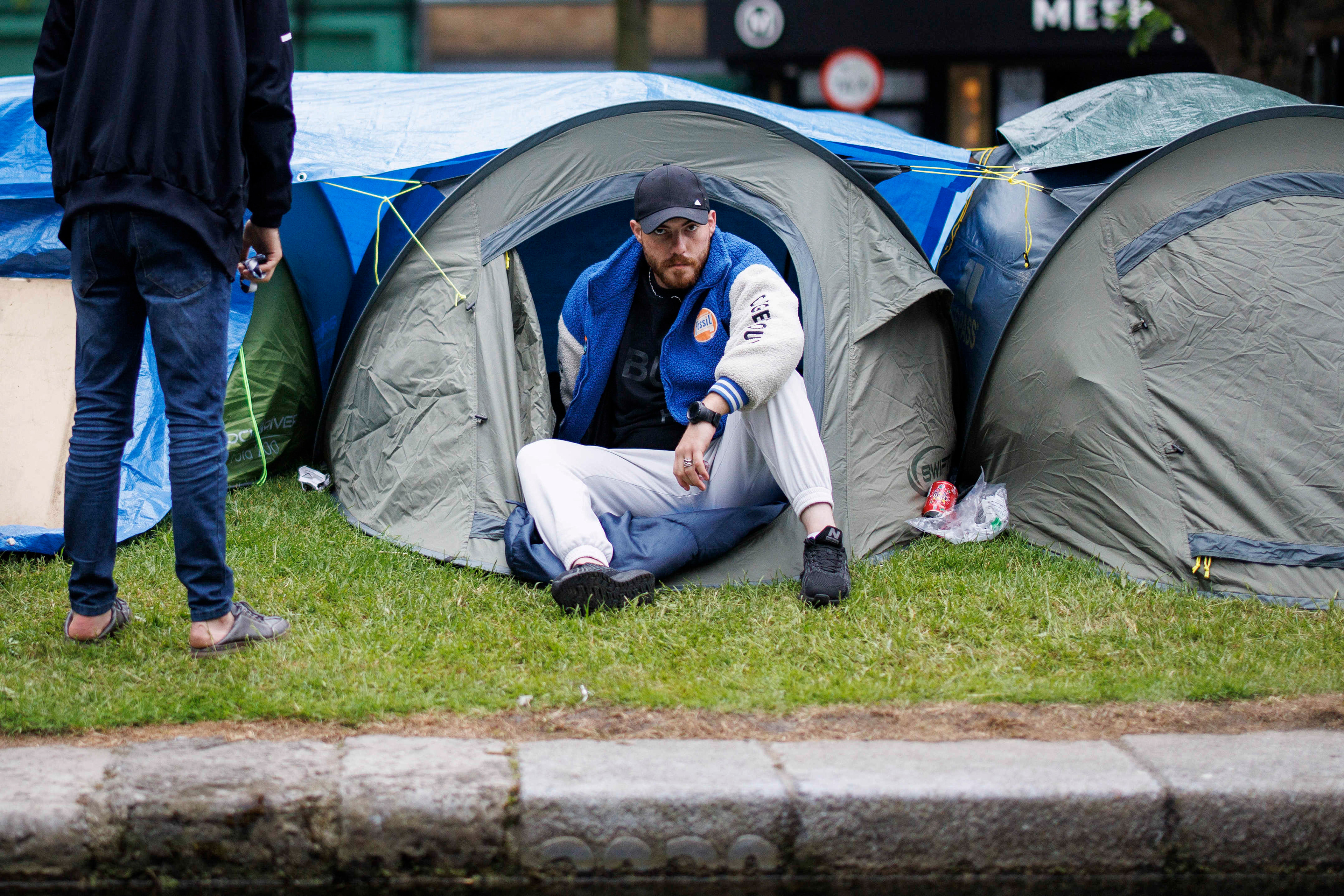 A migrant sits in his tent by Dublin canals