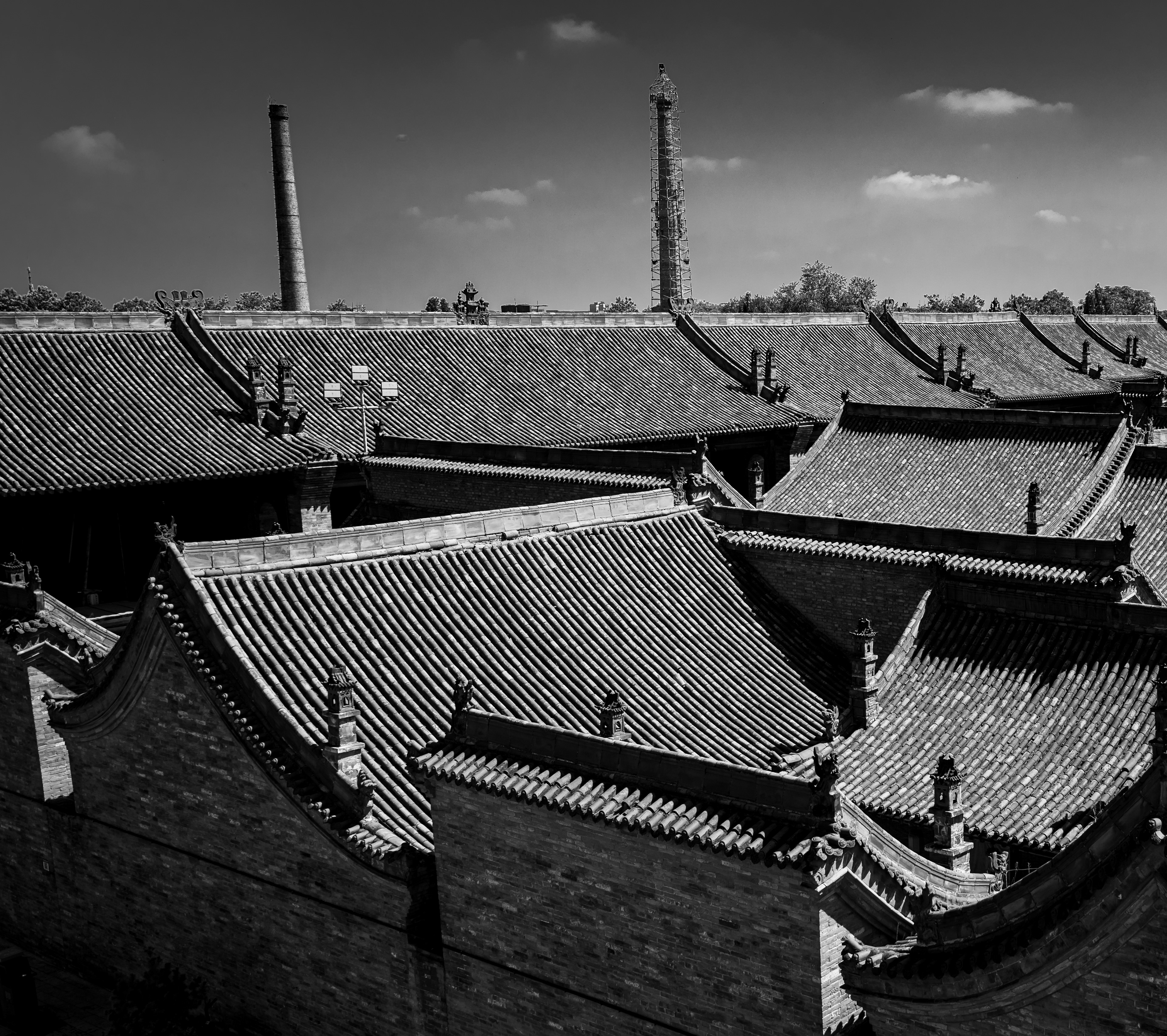 Due tempi: tetti tradizionali cinesi con due ciminiere industriali sullo sfondo, Shanxi, fotografia in bianco e nero di Fabio Alimonti
