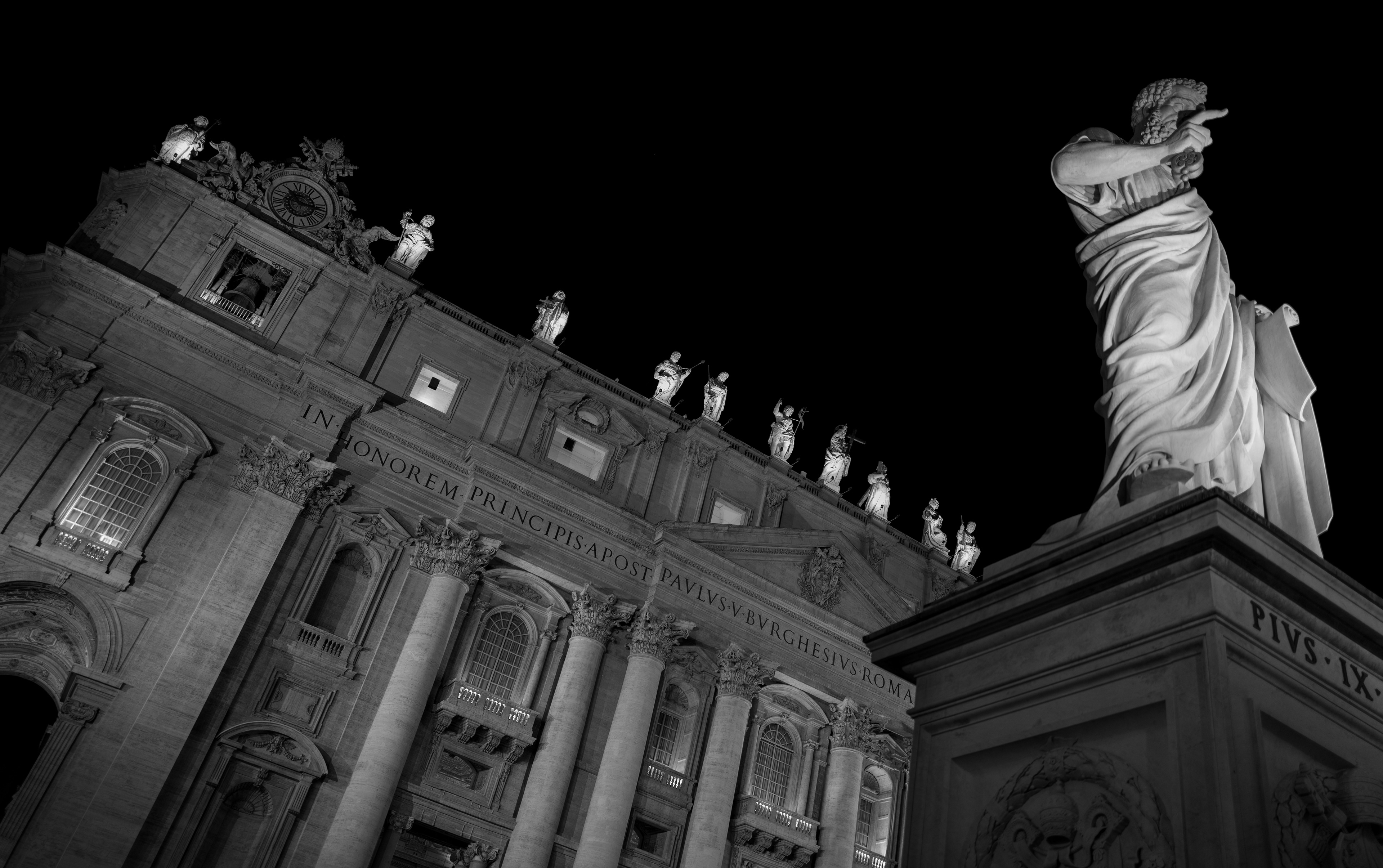 La direzione – statua in marmo che indica, davanti alla facciata della Basilica di San Pietro di notte, fotografia in bianco e nero di Fabio Alimonti