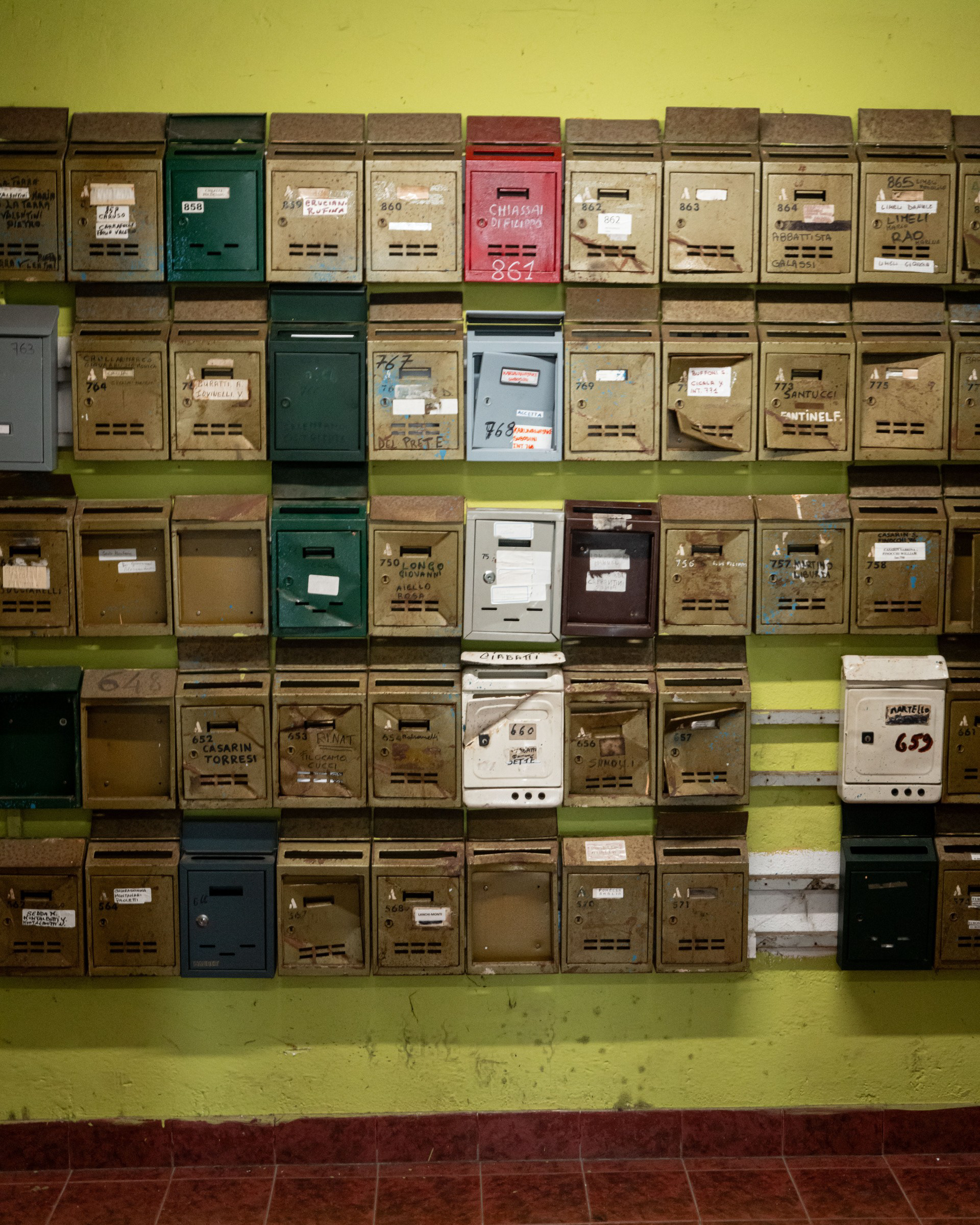 Indirizzi – parete di cassette postali colorate e consumate nell'androne del Serpentone di Corviale, Roma