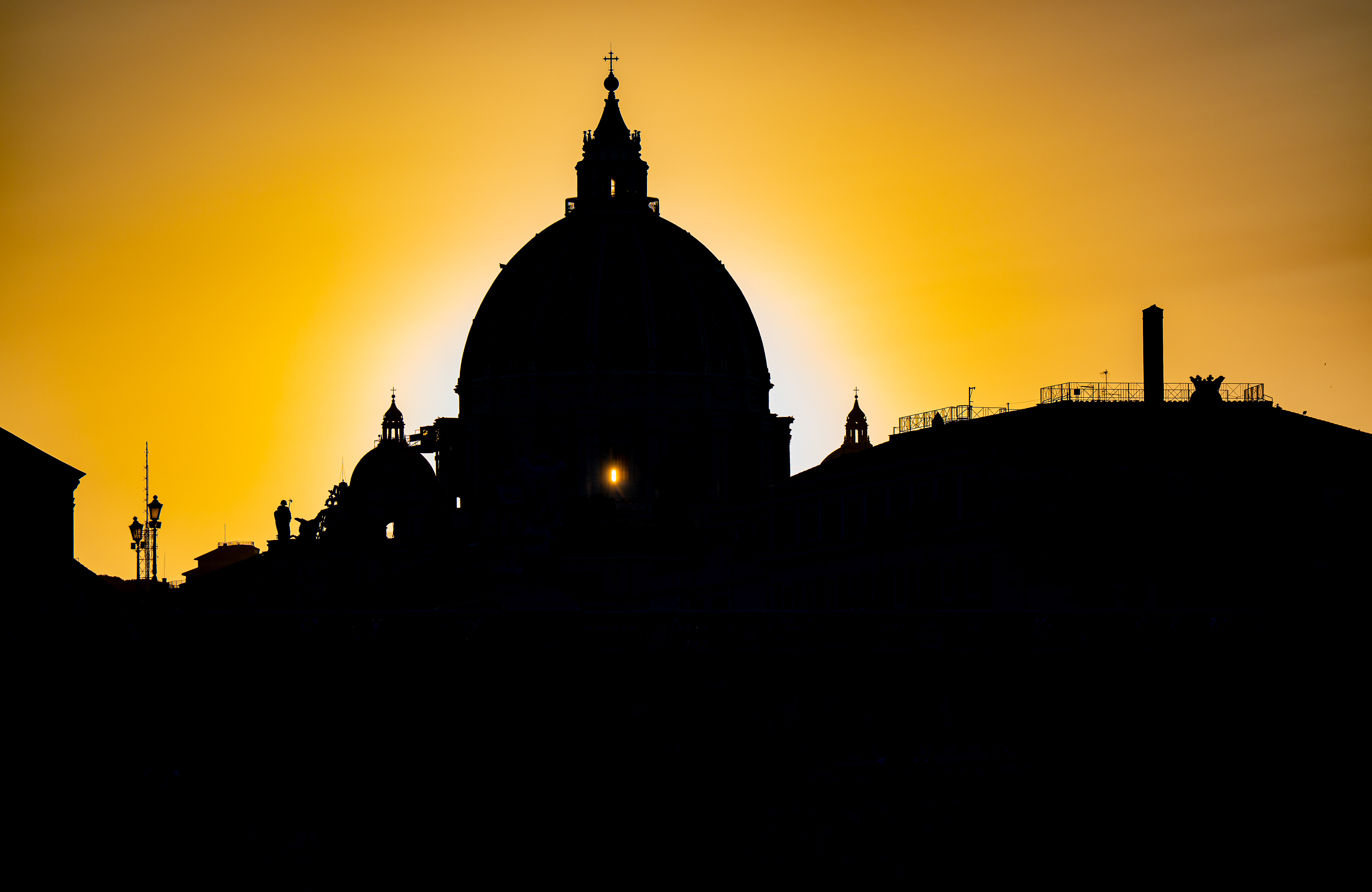 Un solo raggio: la cupola di San Pietro in controluce al tramonto, con un raggio di sole che passa da una finestra della cupola, vista da Ponte Sant'Angelo, Roma, fotografia di Fabio Alimonti