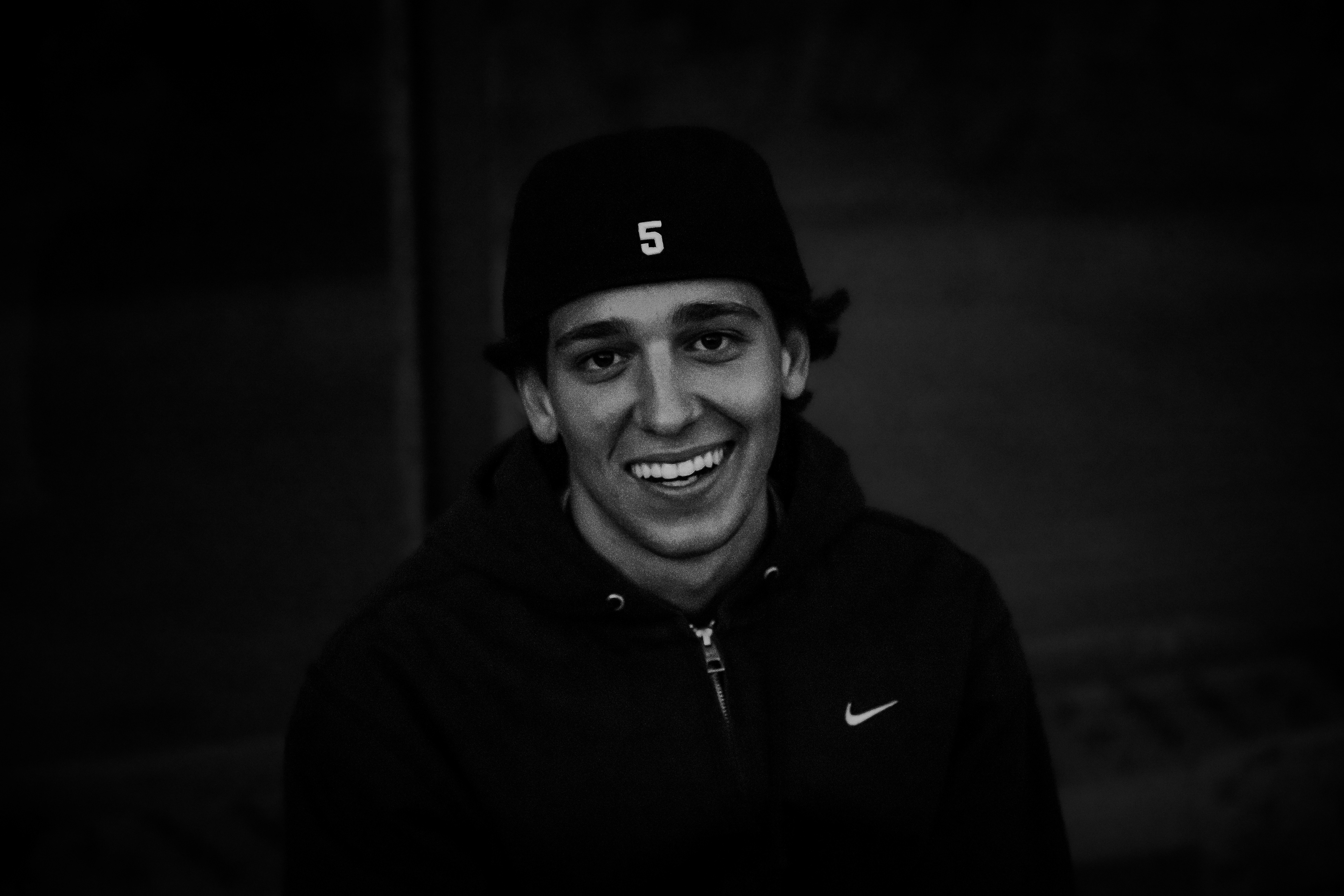 Ritratto di un istante: ragazzo sorridente con berretto e felpa nera, ritratto in bianco e nero a Copenaghen, fotografia di Fabio Alimonti
