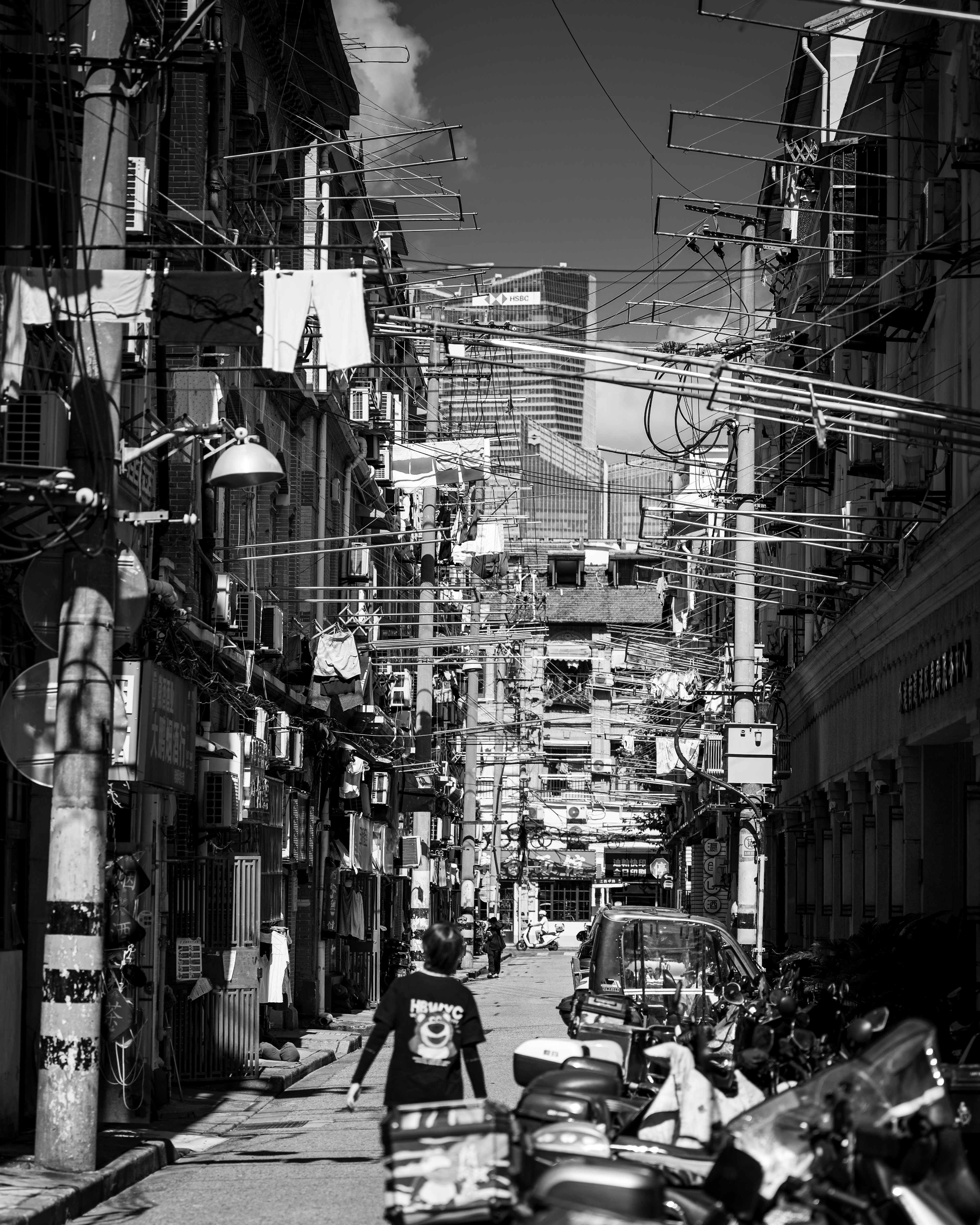 Due Shanghai – vicolo di Shanghai con panni stesi, fili e motorini, la città moderna nella foschia – fotografia di Fabio Alimonti