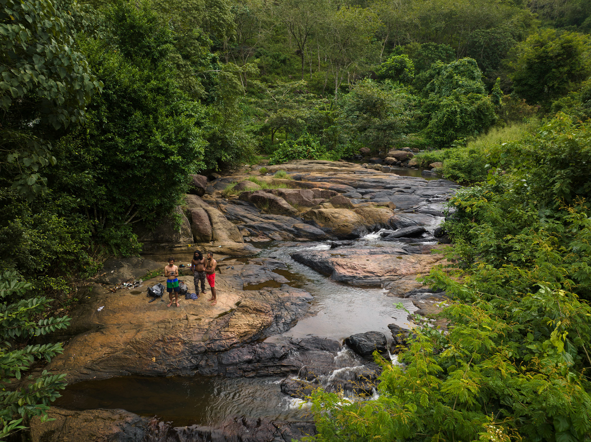 Aerial view of 3 friends hanging out in river in Mathugama, Sri Lanka