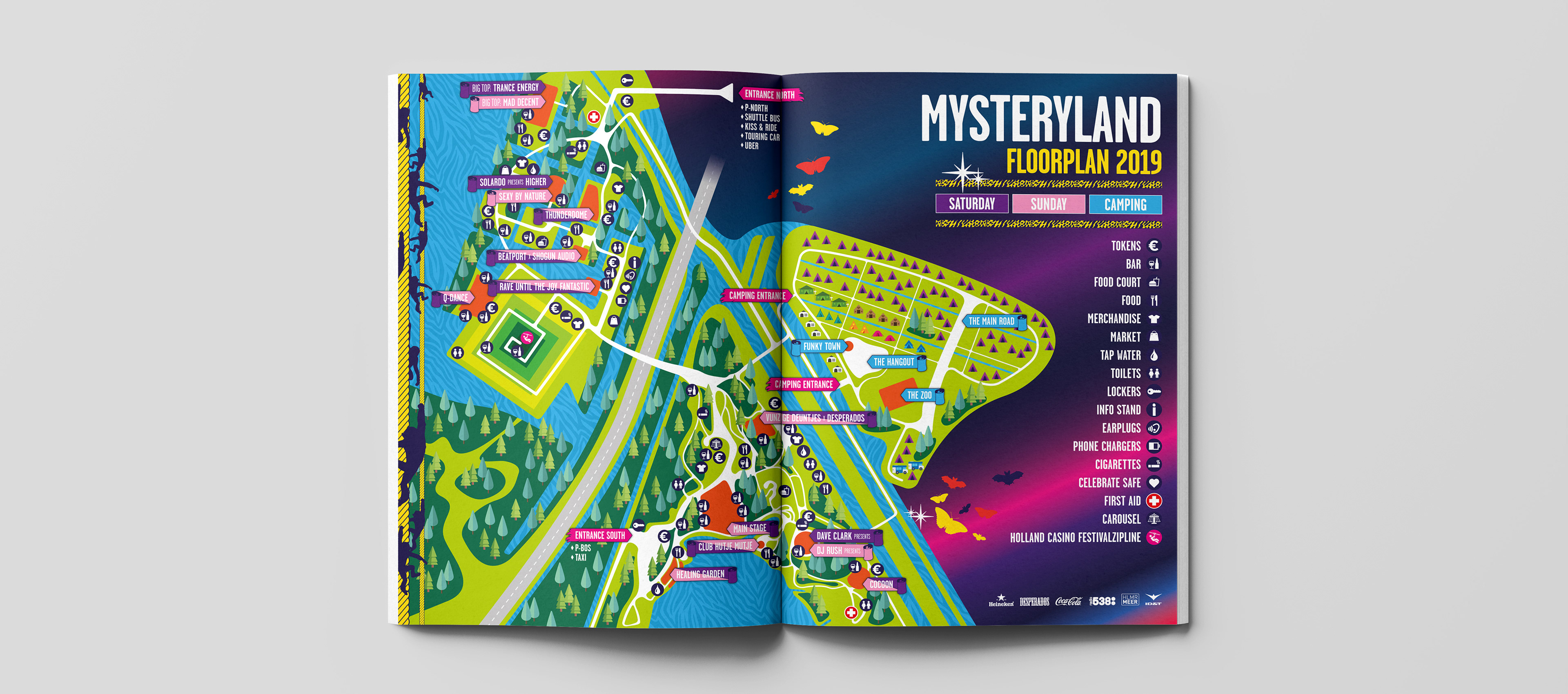 A colorful Mysteryland festival floorplan for 2019 open in a magazine, highlighting different stages and amenities.